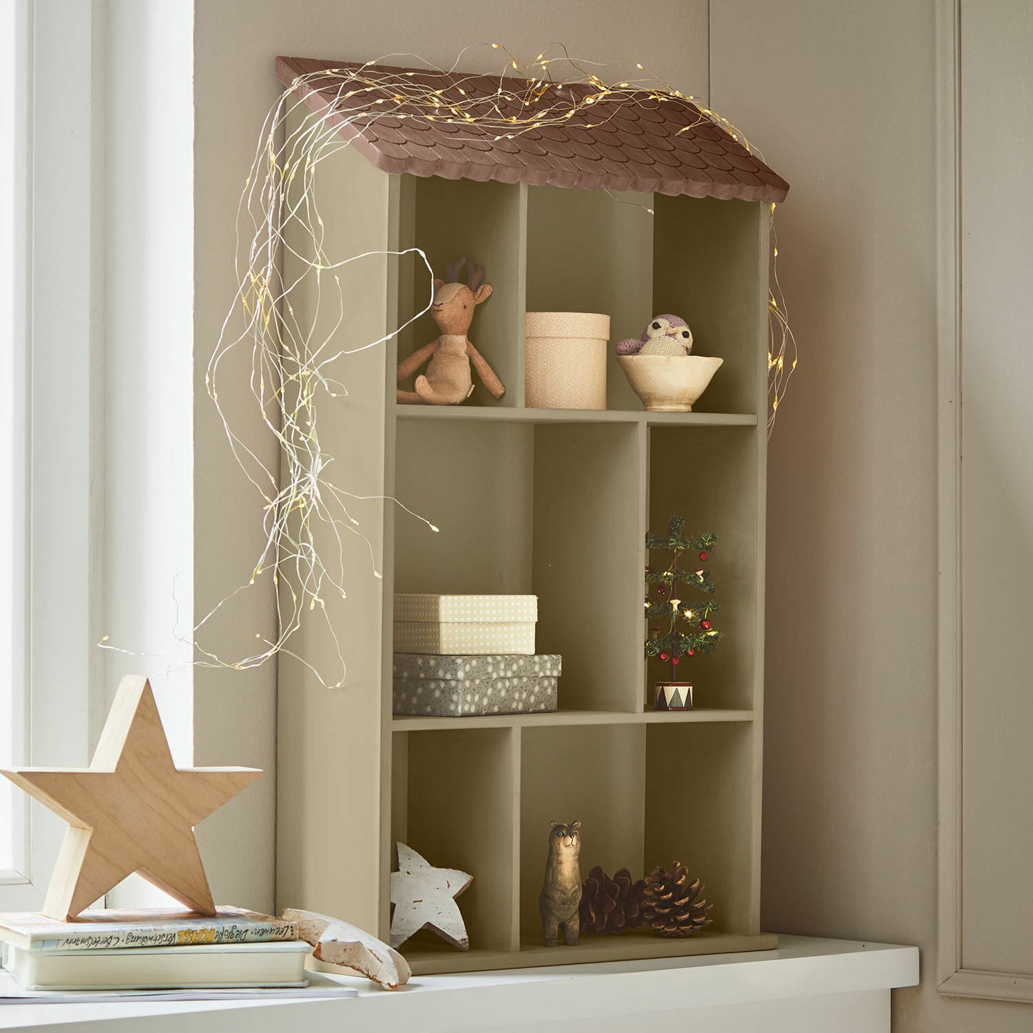 Estante de pared Zerith Estantería de madera en forma de casa color oliva con decoración navideña y luces LED