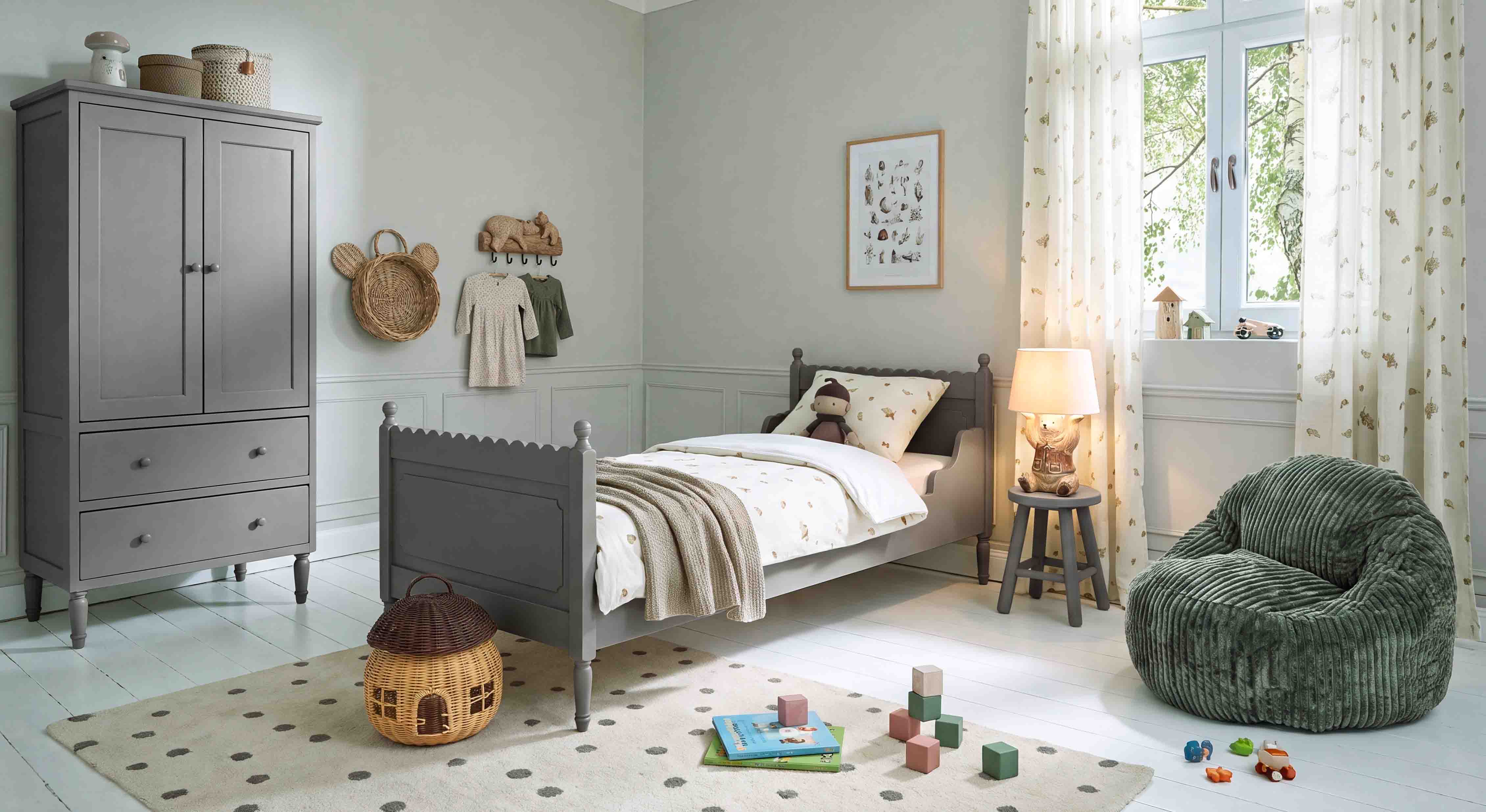 Armario y cama de madera gris en habitación infantil con sillón verde suave y decoraciones