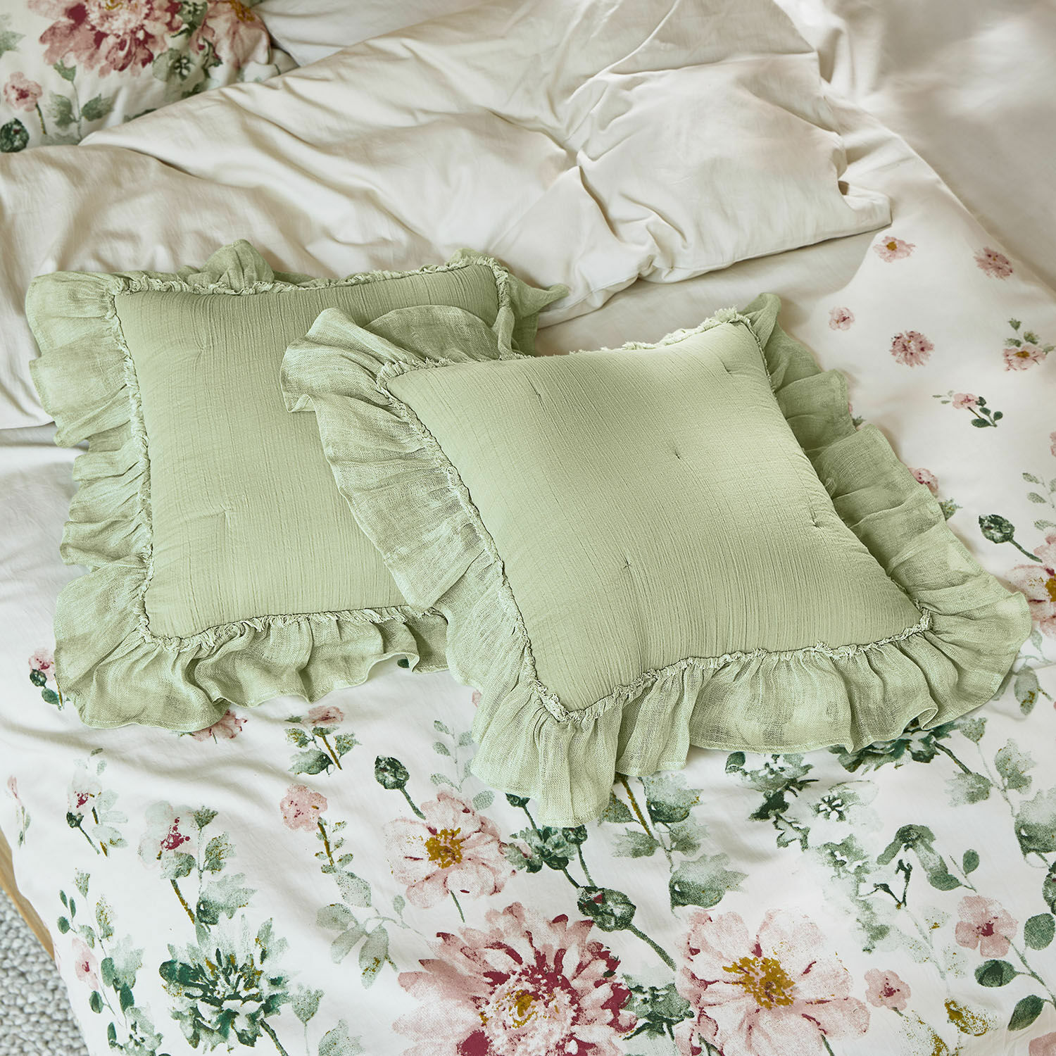 Cojines verdes de lino con volantes sobre ropa de cama floral, decoración de dormitorio, textiles para el hogar