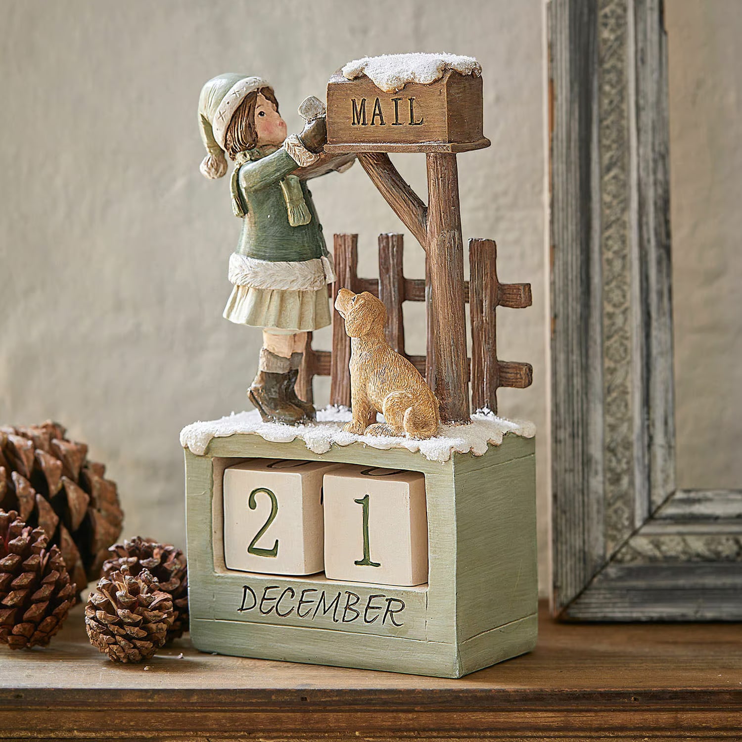 Calendario de adviento de madera con figura de niña y perro junto a buzón con nieve para decoración invernal