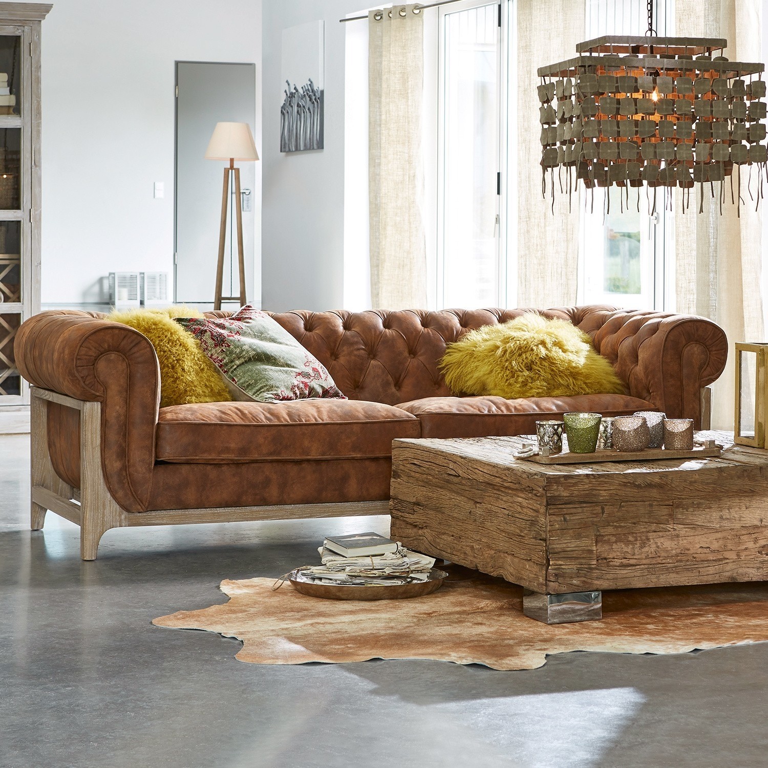 Sofá Swansboro Sofá Chesterfield de cuero marrón con marco de madera y cojines amarillos en sala moderna