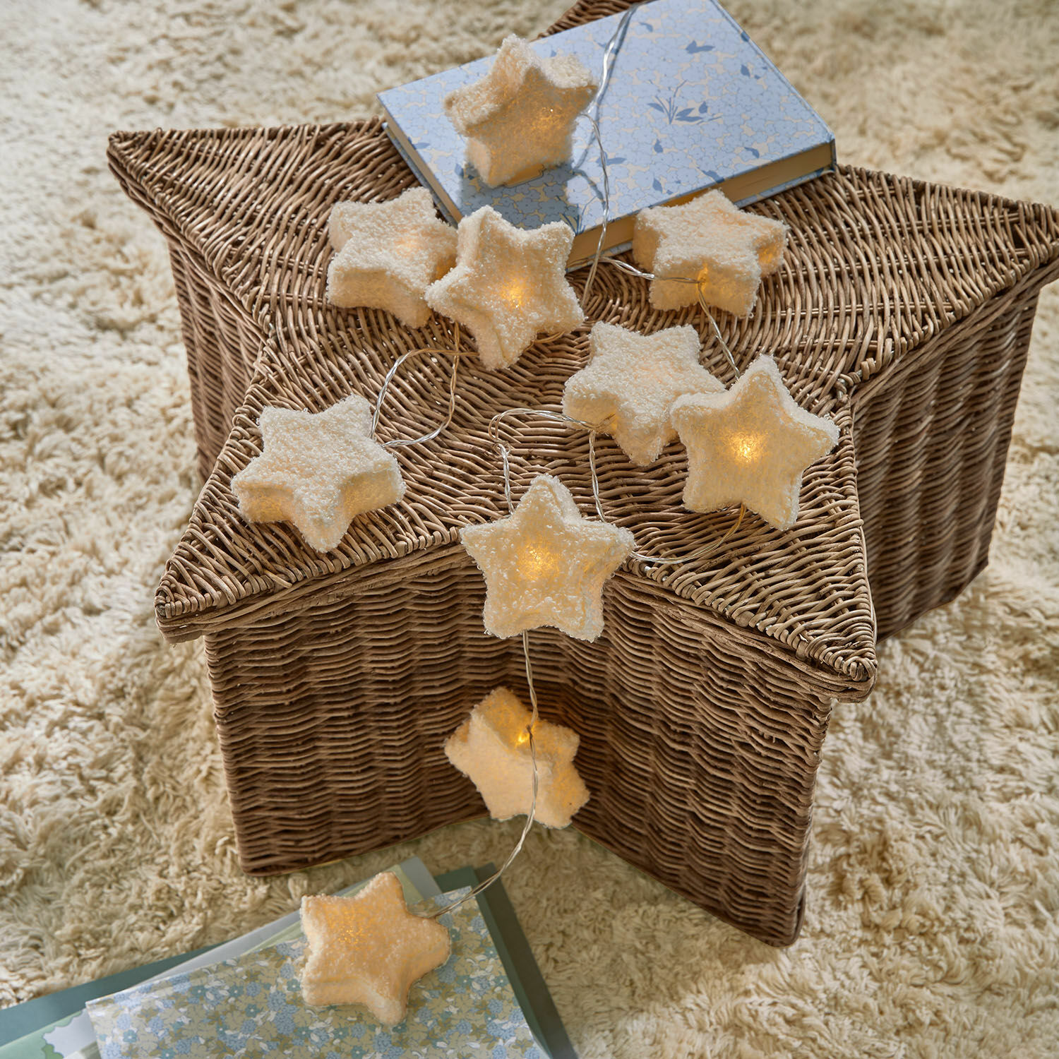 Luces de hadas Starwhisper Guirnalda de luces en forma de estrellas de material suave con luz cálida sobre cesta de mimbre, decoración