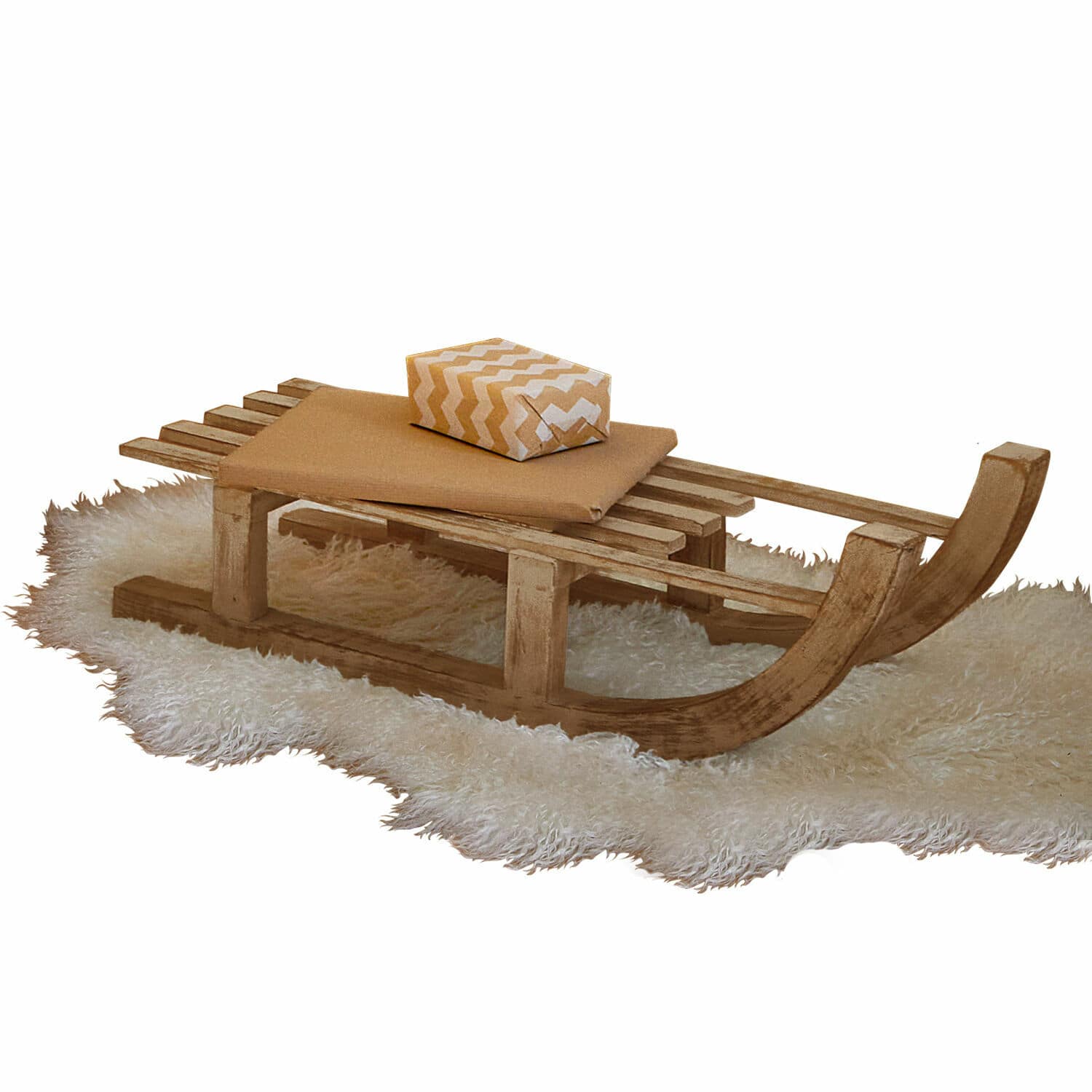 Trineo decorativo FSC®-100% Hoekstra Trineo de madera sobre alfombra blanca de piel con cojín y regalo en tonos beige