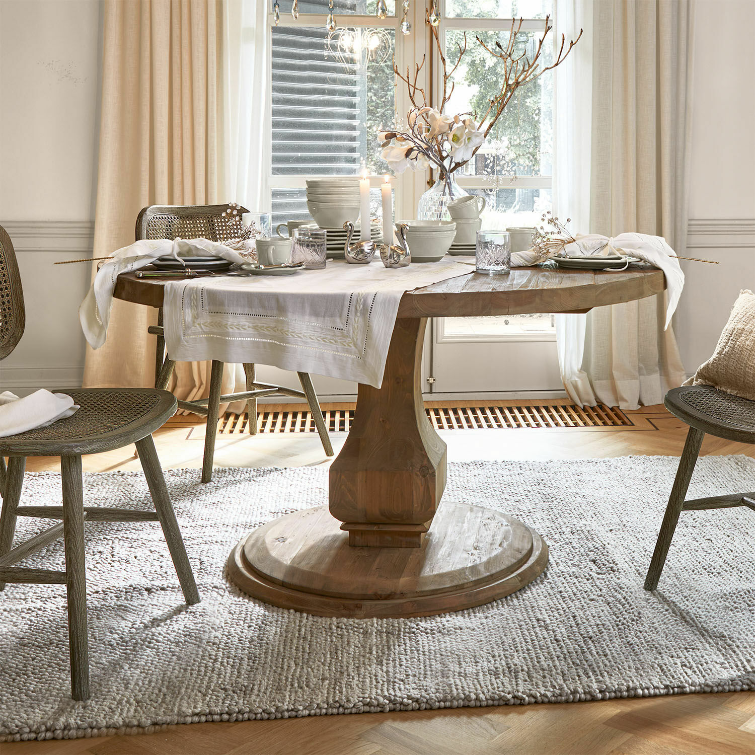 Mesa Alderwick Mesa redonda de madera con mantel blanco y decoración en comedor luminoso y acogedor con luz natural