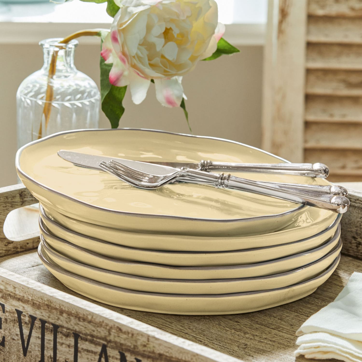 Set de 6 platos Biarré Juego de platos de cerámica crema con borde metálico y cubiertos plateados sobre bandeja de madera