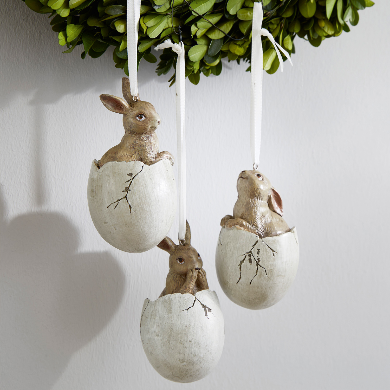 Tres adornos colgantes con conejos en cáscaras de huevo blancas, decoración de Pascua