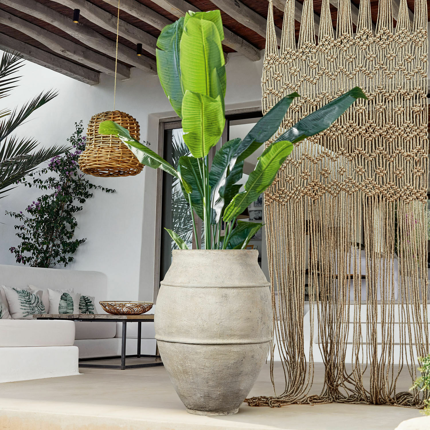 Tinaja Morcote Maceta grande de hormigón gris con planta verde en interior moderno con lámpara colgante de mimbre