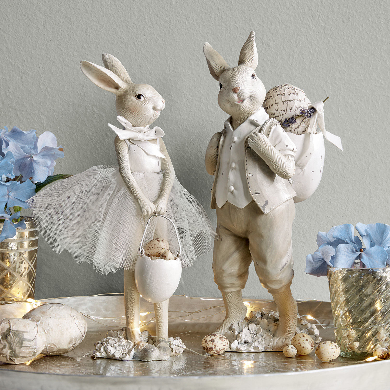 Conejito set de 2 Perpignan Figuras decorativas de conejos claros con accesorios de Pascua y flores sobre una mesa