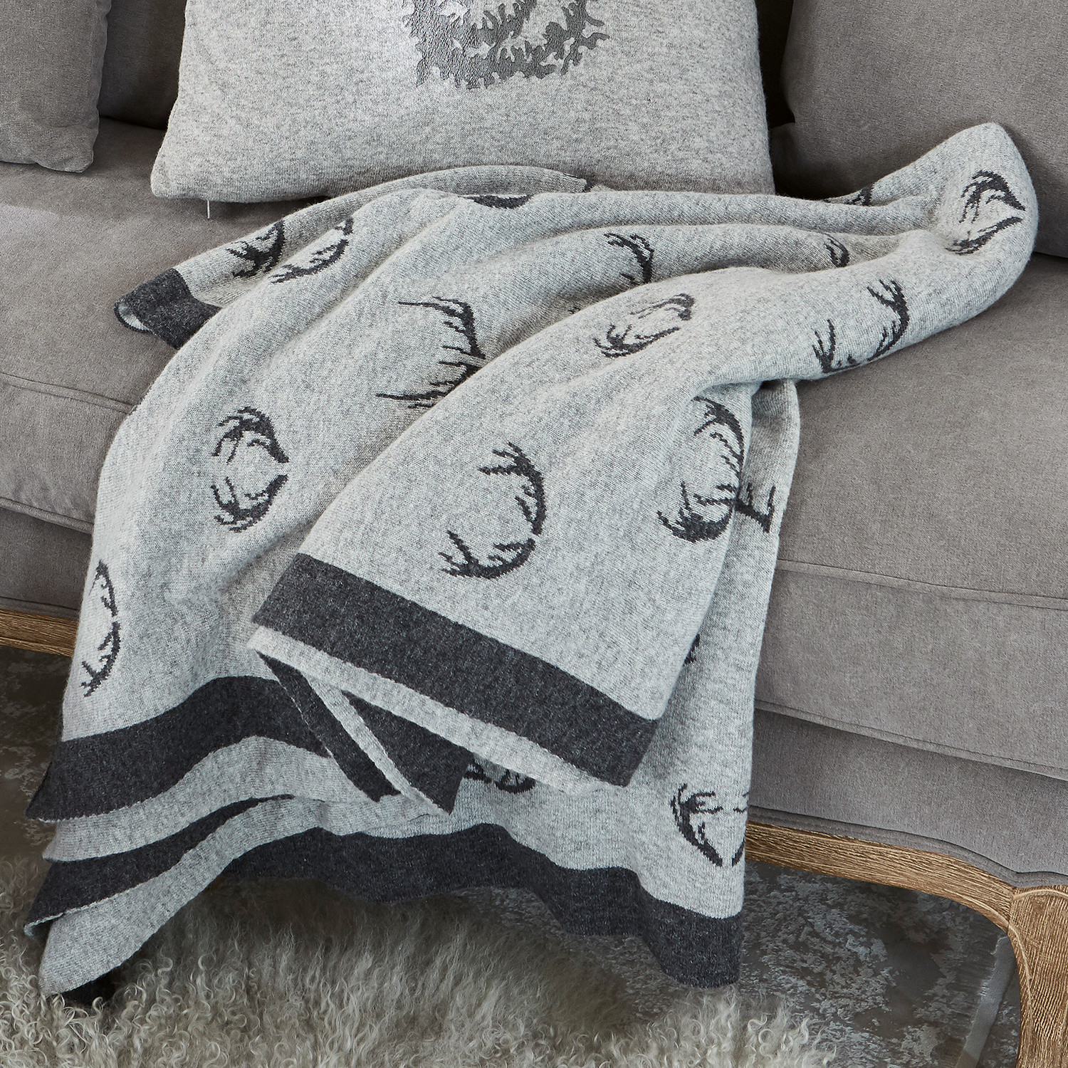 Manta reversible Lodge Manta de lana gris con diseño de astas negras sobre sofá gris, decoración y confort en casa