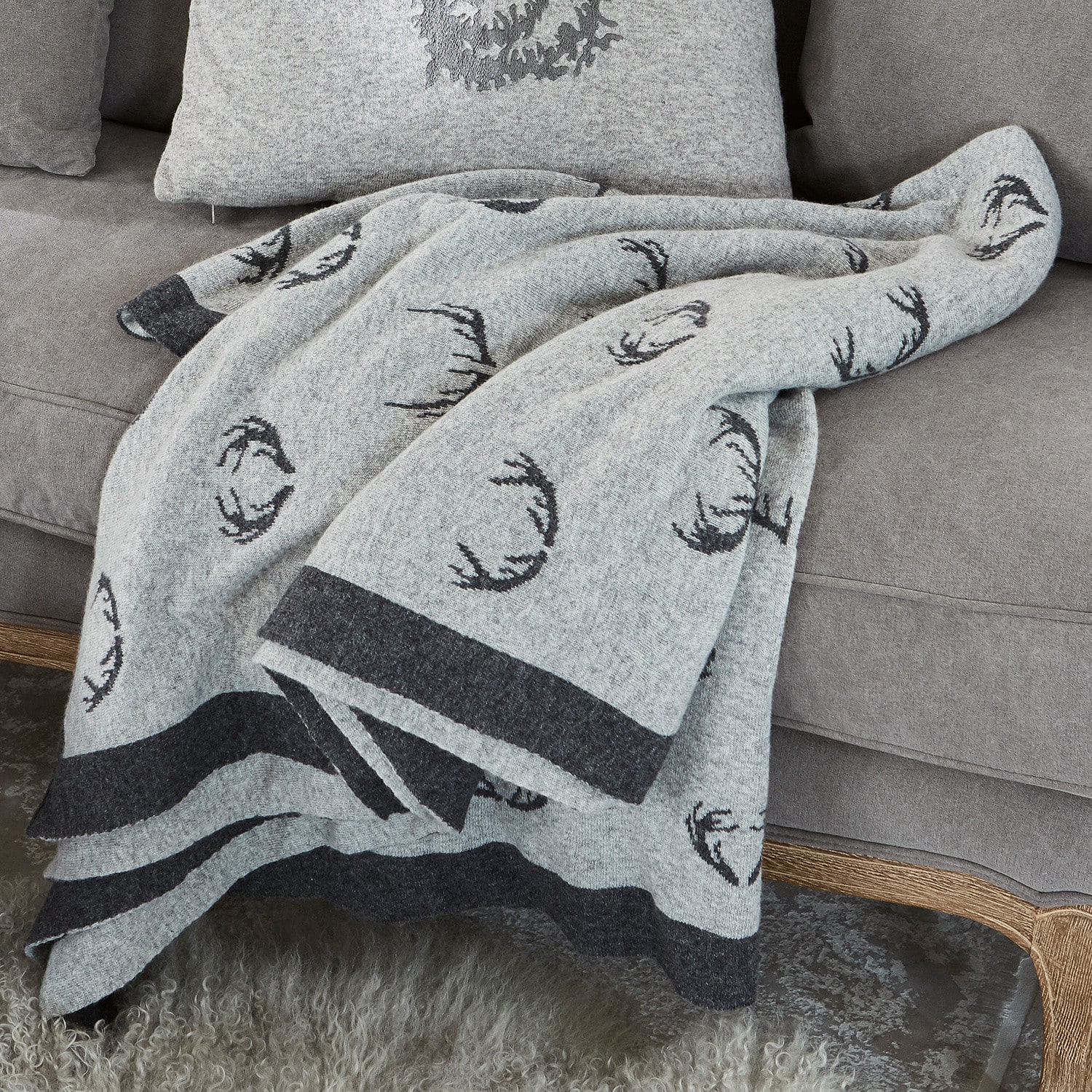 Manta reversible Lodge Manta de lana gris con diseño de astas negras sobre sofá gris, decoración y confort en casa
