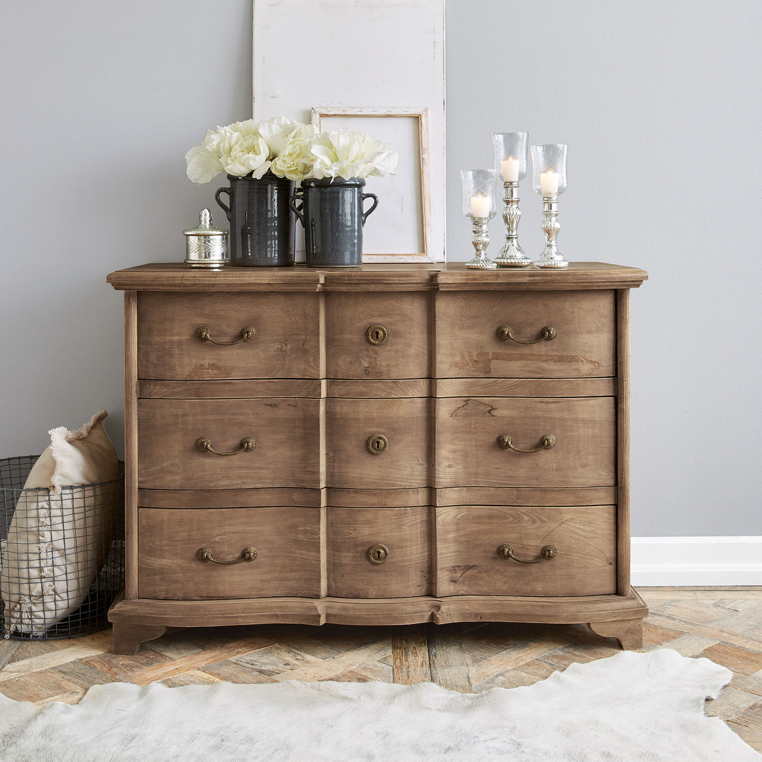 Cómoda Aiguillon Cómoda de madera natural con seis cajones y decoraciones sobre la superficie en interior moderno