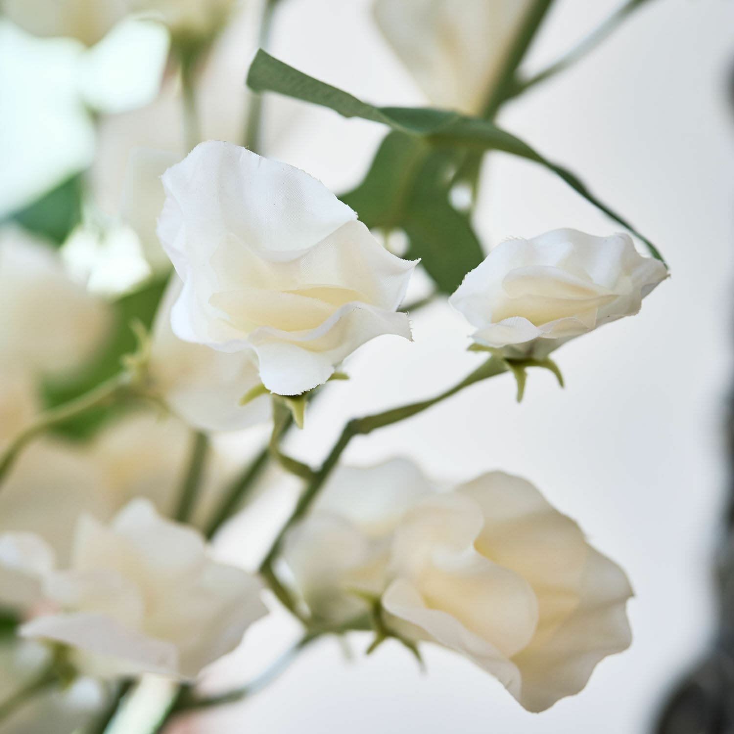 Flores artificiales blancas de tela con tallos verdes para decoración interior delicada