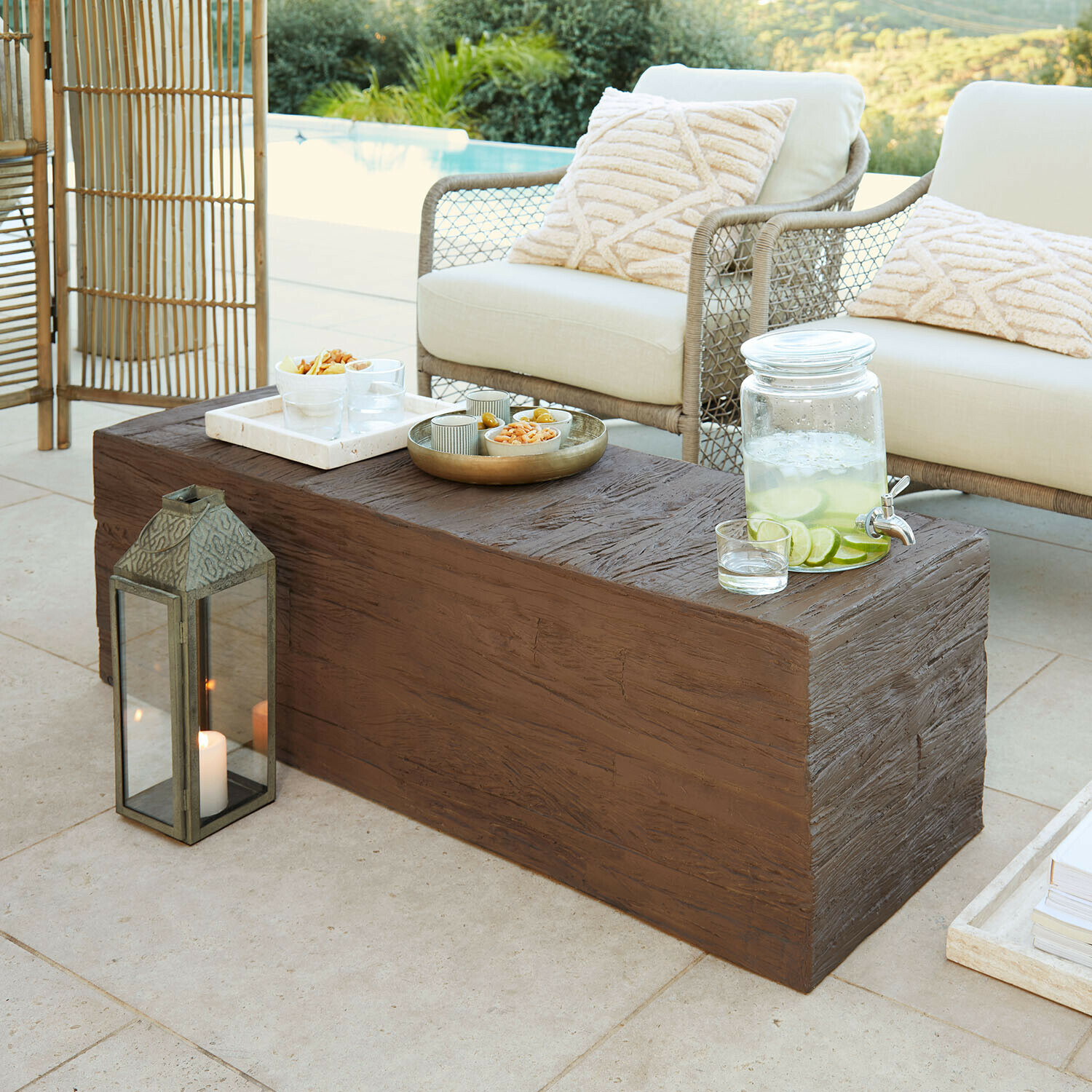 Mesa de centro Fenwarden Mesa de centro marrón con textura de madera en terraza con cojines crema y jarra de limonada