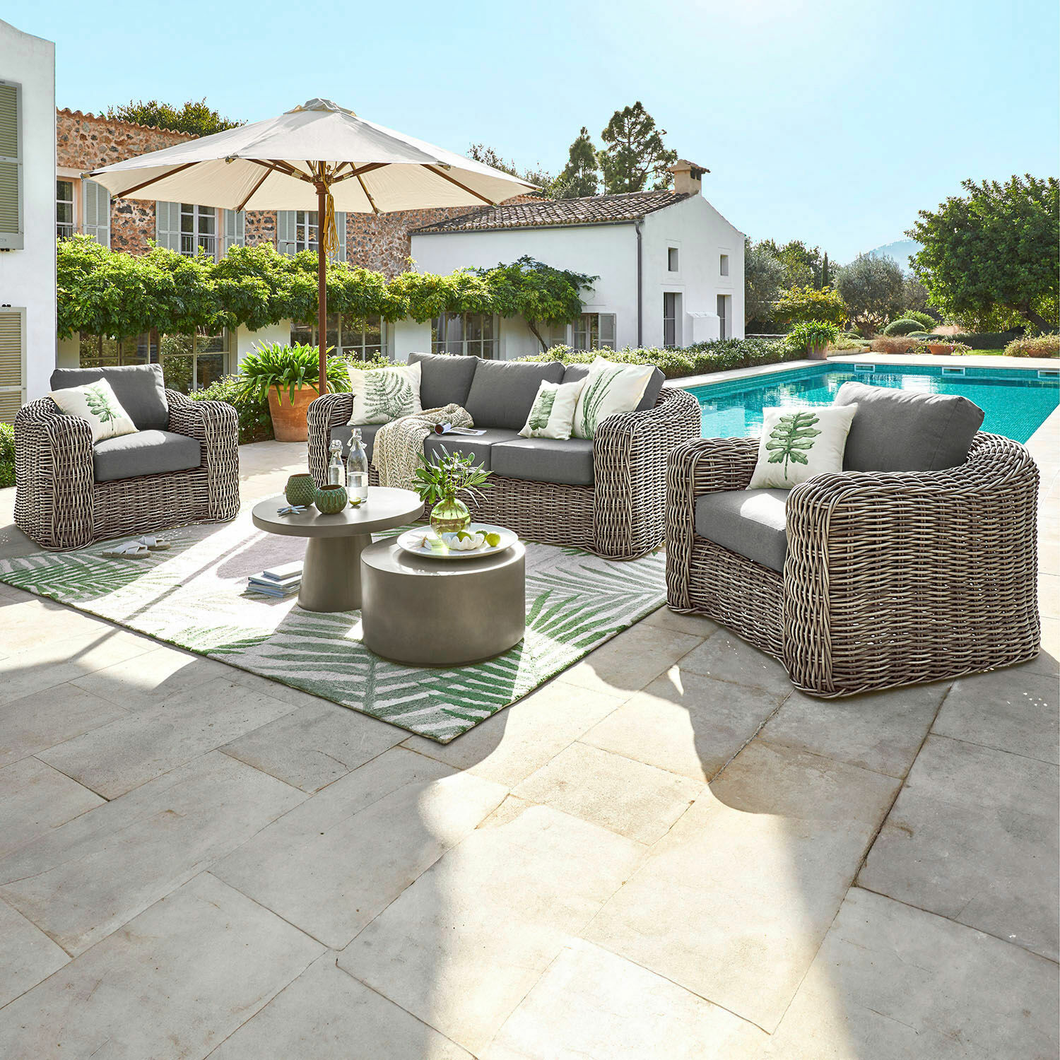 Grupo de asientos Upminster Conjunto de muebles de jardín de tecnoratán gris con cojines y sombrilla junto a la piscina
