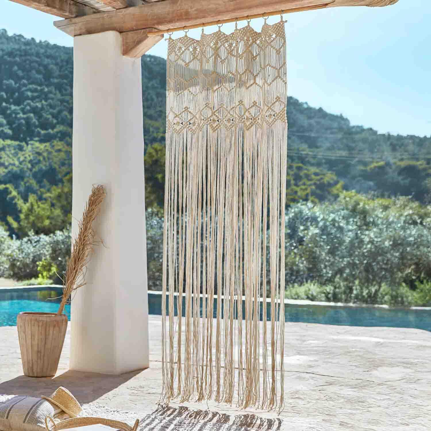 Macramé beige de algodón colgado de viga de madera, decoración bohemia para terraza con vista a la piscina