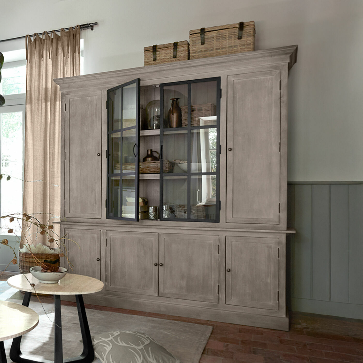 Armario Valandor Gran vitrina de madera gris con puertas de cristal y cestas encima en sala de estar