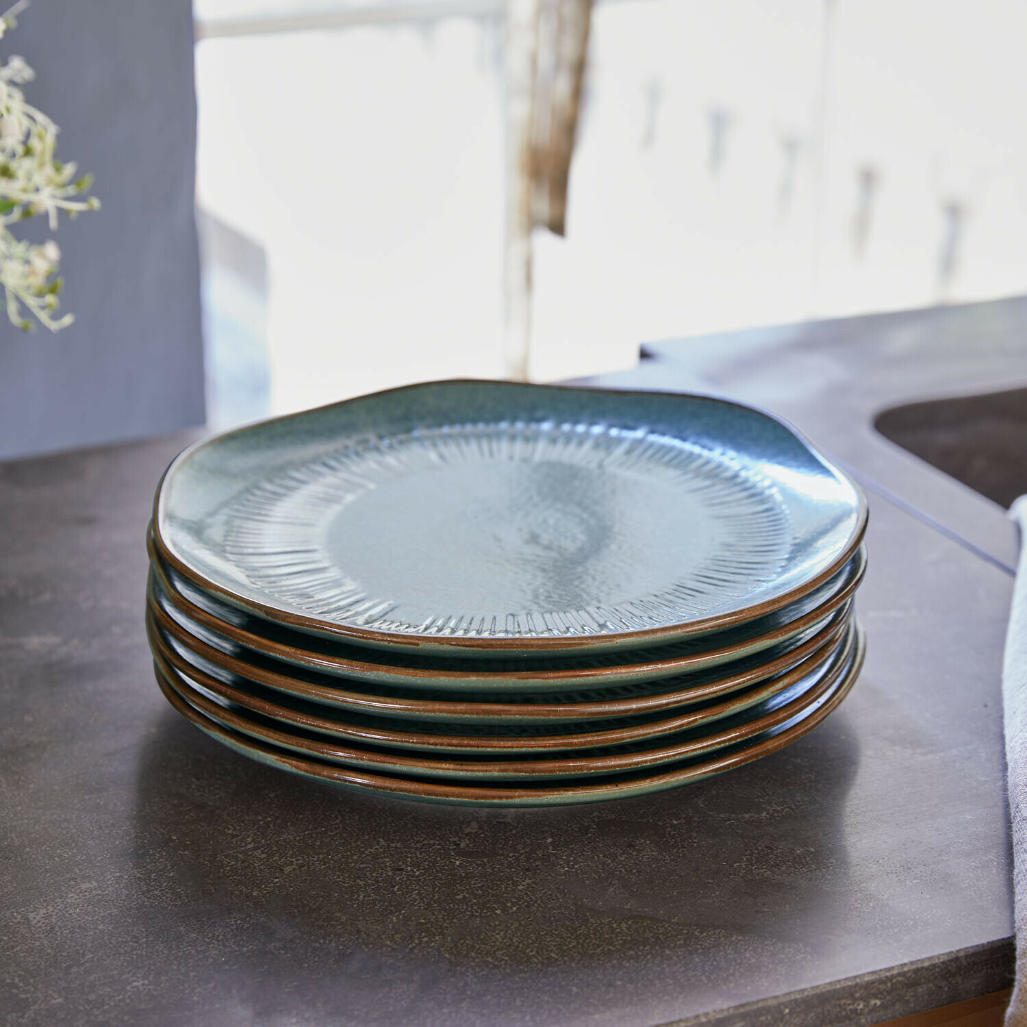Set de 6 platos de postre Périers Conjunto de seis platos de cerámica verde con borde marrón apilados en encimera