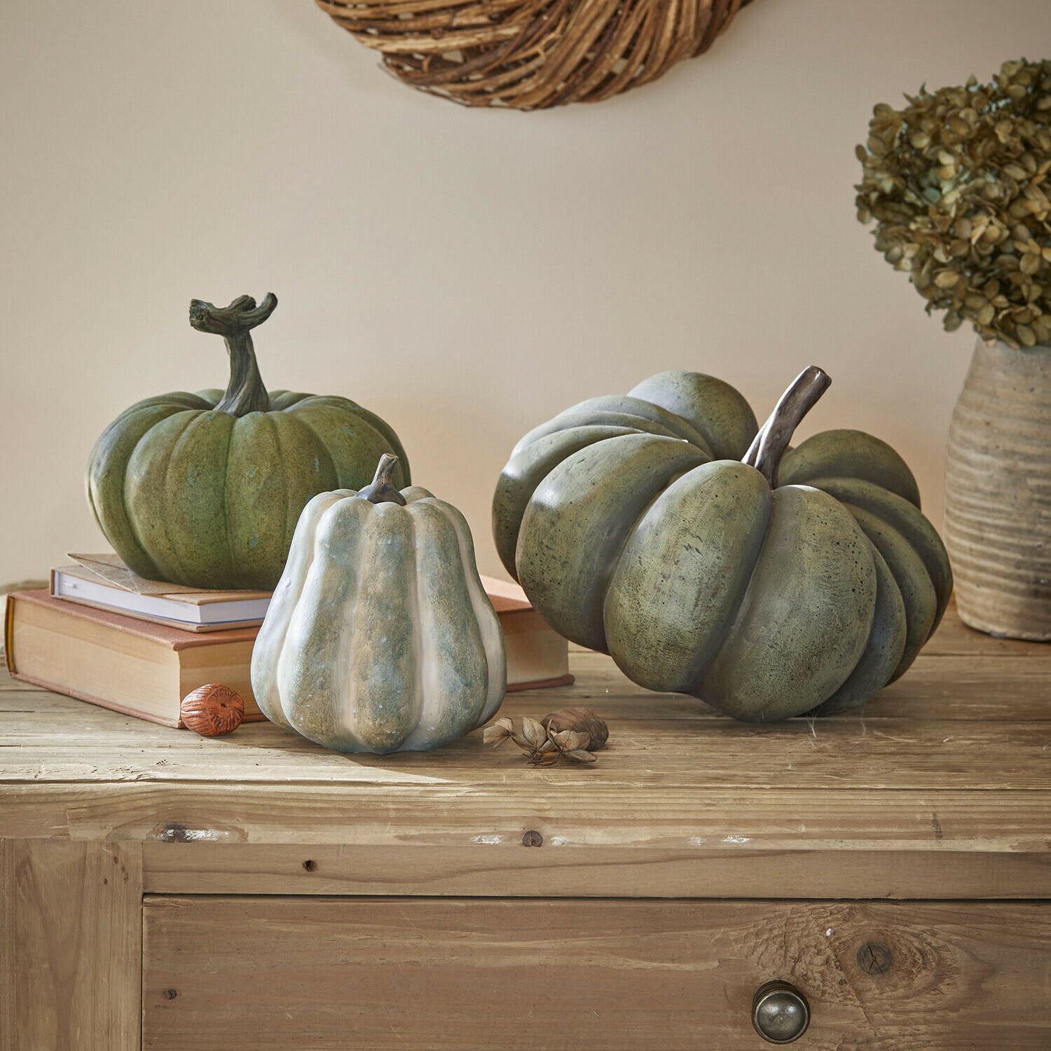 Set de 3 calabazas Veronira Calabazas decorativas verdes y blancas sobre mesa de madera con libros y flores secas