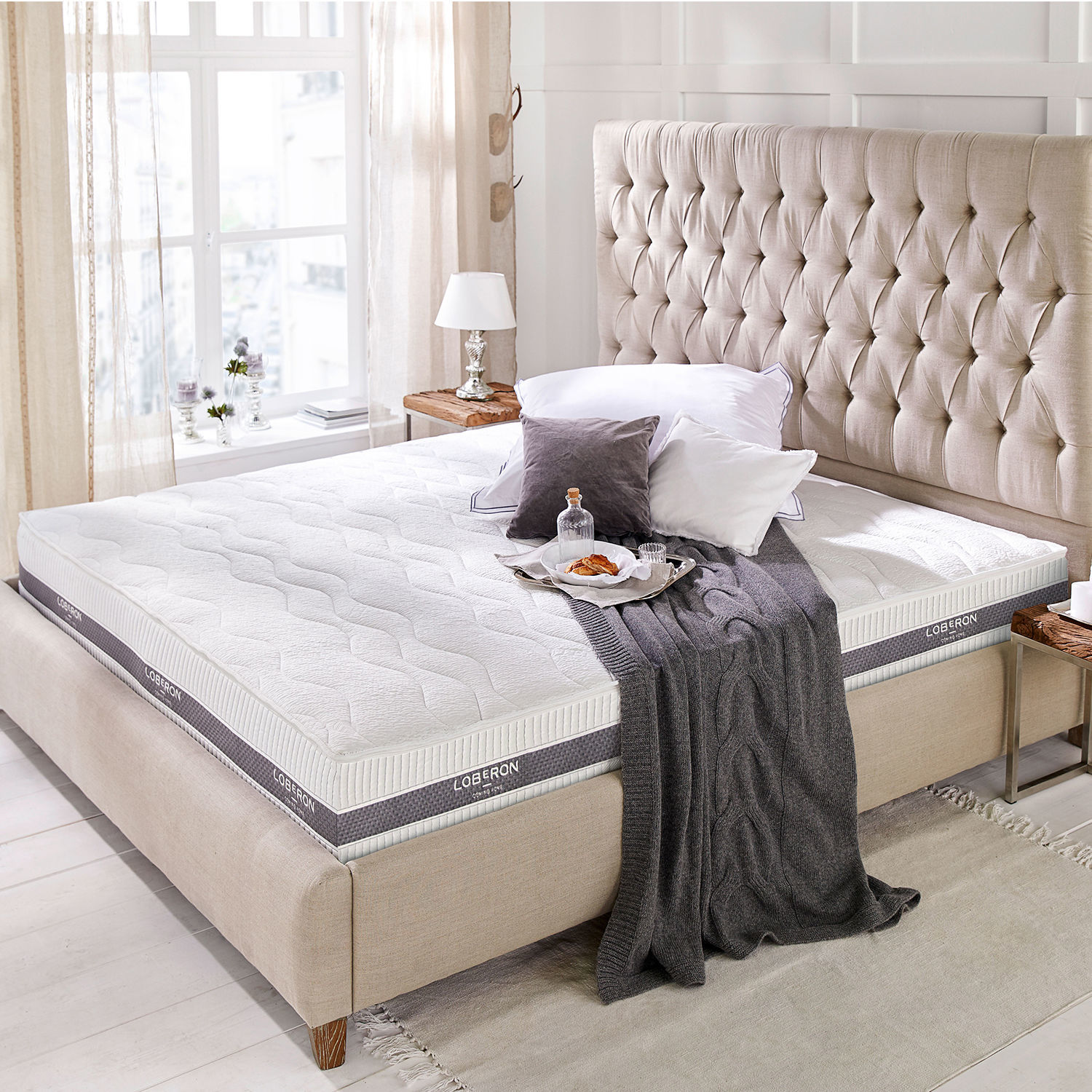 Colchón 180x200 Turim Colchón blanco moderno Loberon sobre cama beige con cabecero capitoné en habitación luminosa