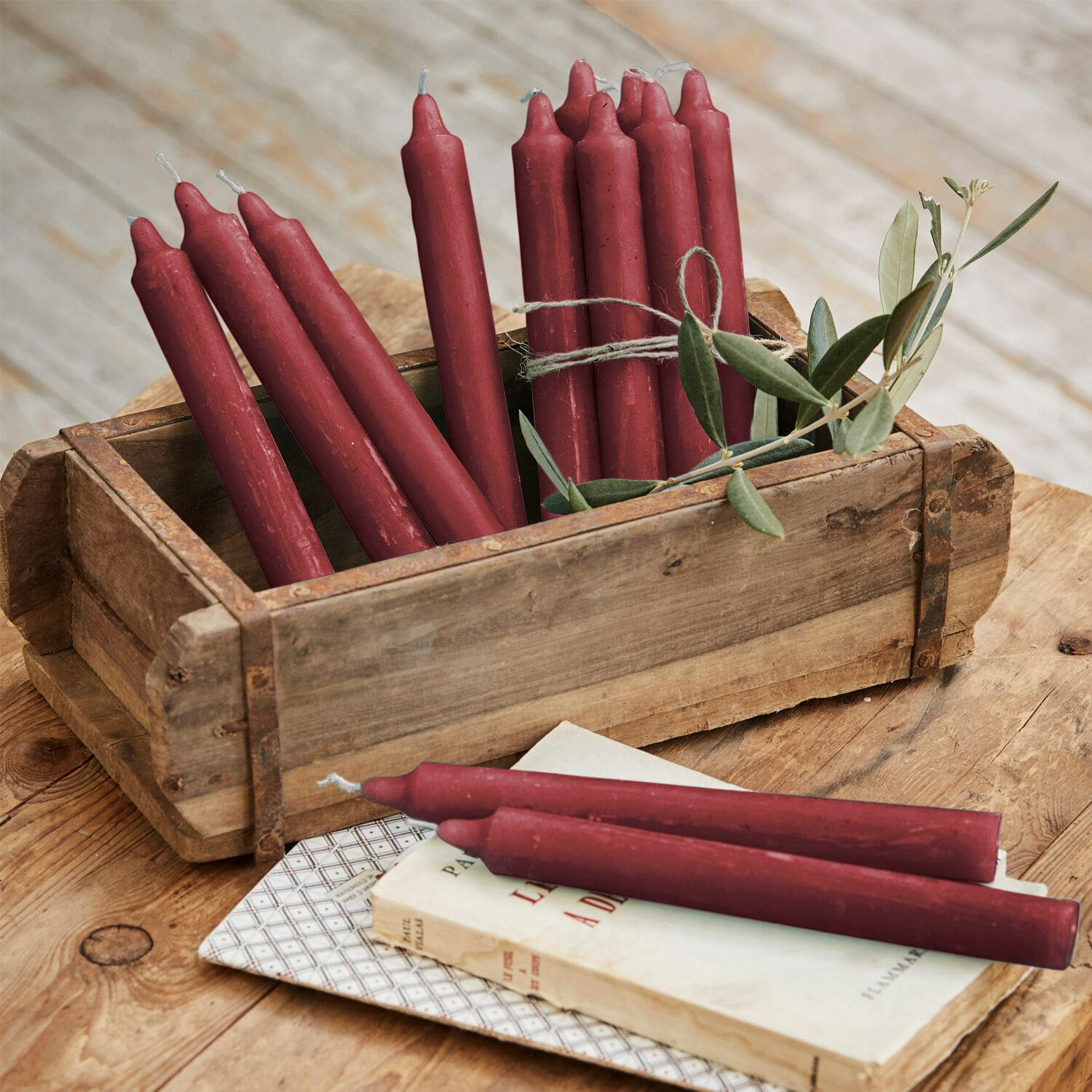 Set de 12 velas Bauceau Conjunto de velas rojas de cera en caja de madera sobre mesa rústica
