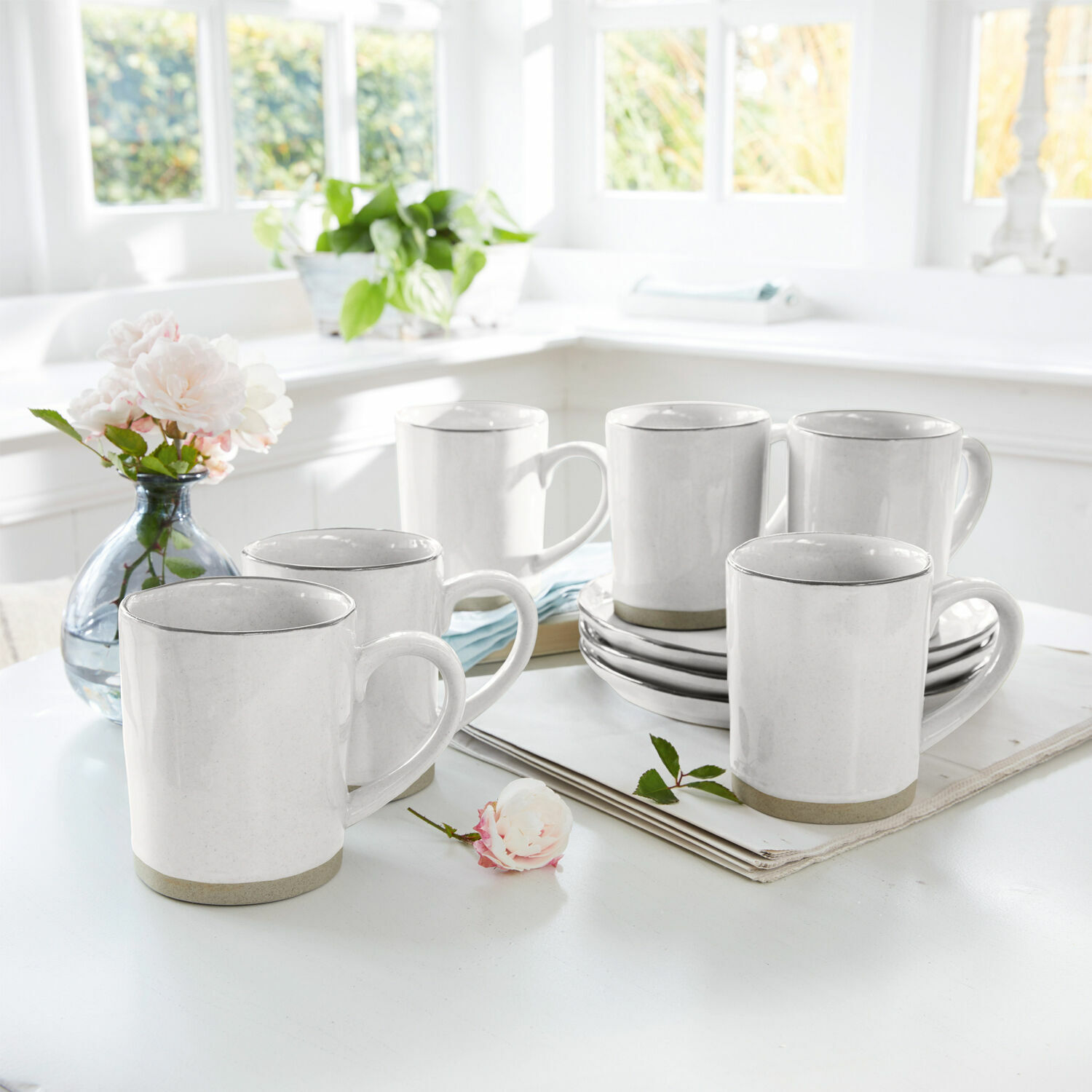 Set de 6 tazas Biarré Conjunto de seis tazas de cerámica blanca con borde gris sobre mesa clara en interior luminoso