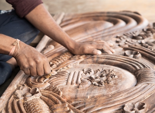 Tallado manual en madera con motivos florales decorativos, detalle de artesanía artística