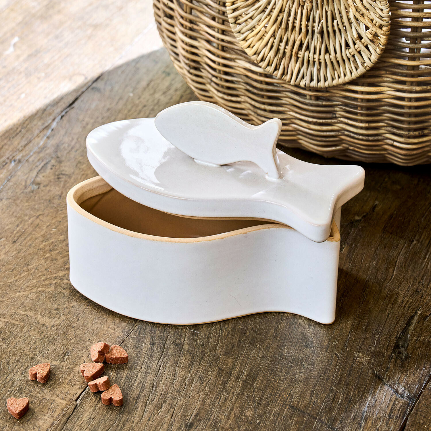 Recipiente de cerámica blanca con forma de pez y tapa sobre mesa de madera, decoración y almacenamiento