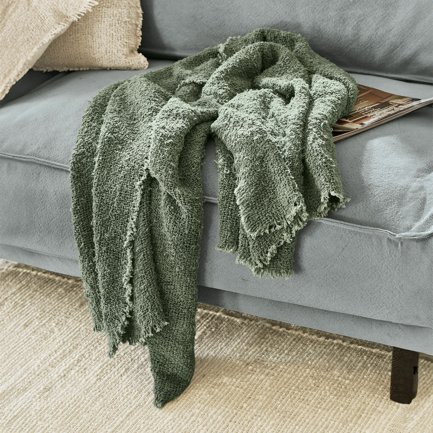 Plaid Juliana Manta verde suave de algodón sobre sofá gris, accesorio decorativo y acogedor para salón