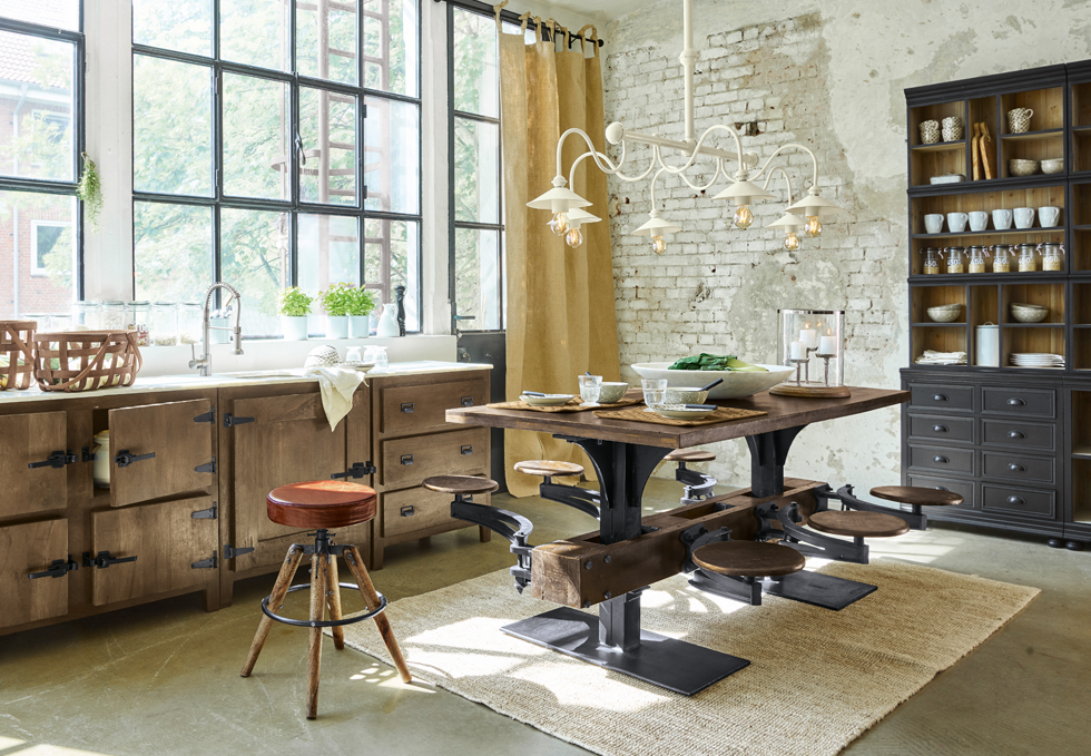 Mesa de comedor industrial de madera y metal con taburetes integrados en cocina luminosa con ventana grande