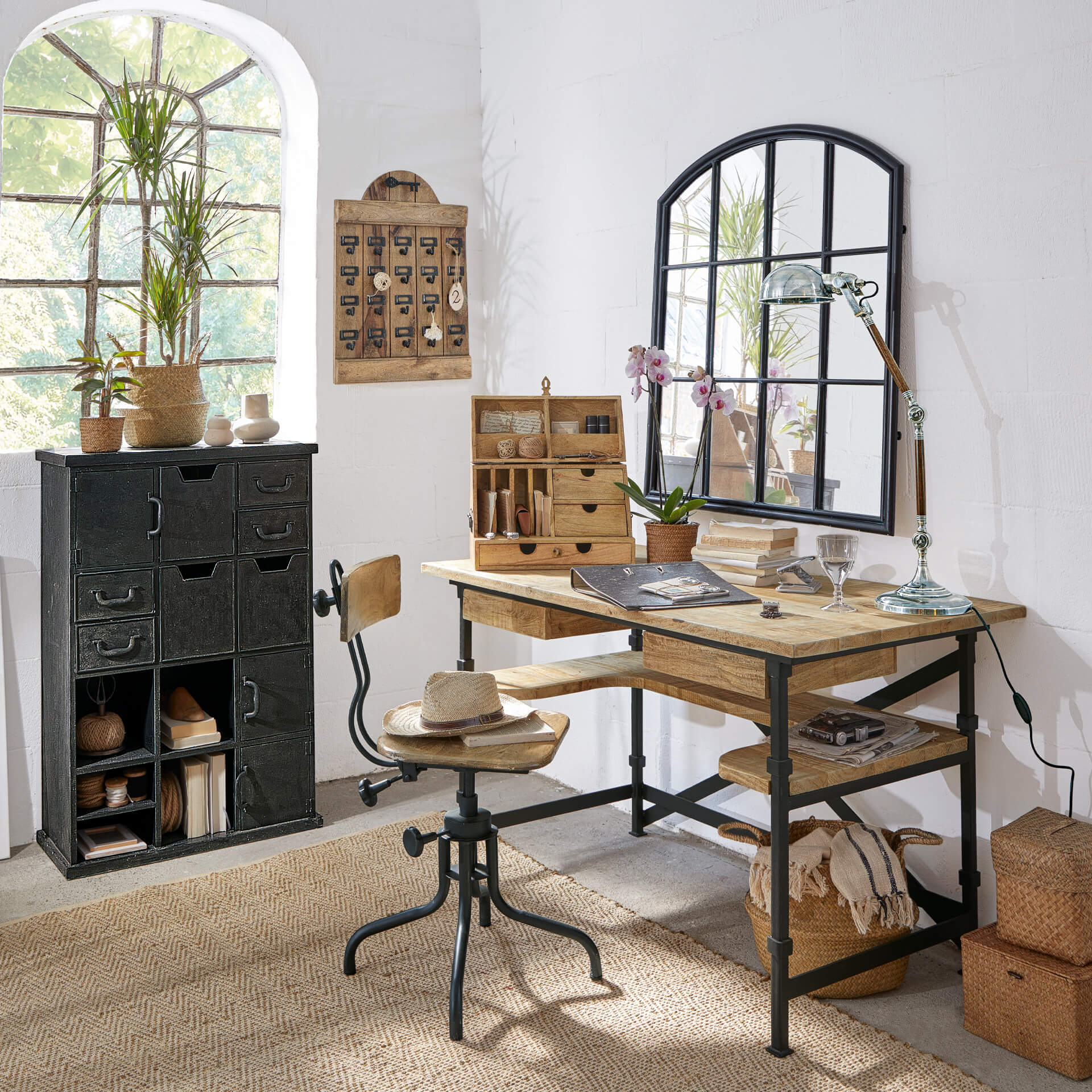 Escritorio y silla de madera y metal estilo industrial en habitación luminosa con decoración y espejo
