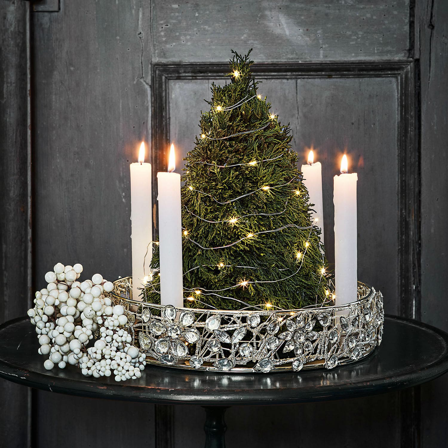 Árbol decorativo Moran Candelabro decorativo con velas blancas y árbol verde con luces LED sobre mesa negra