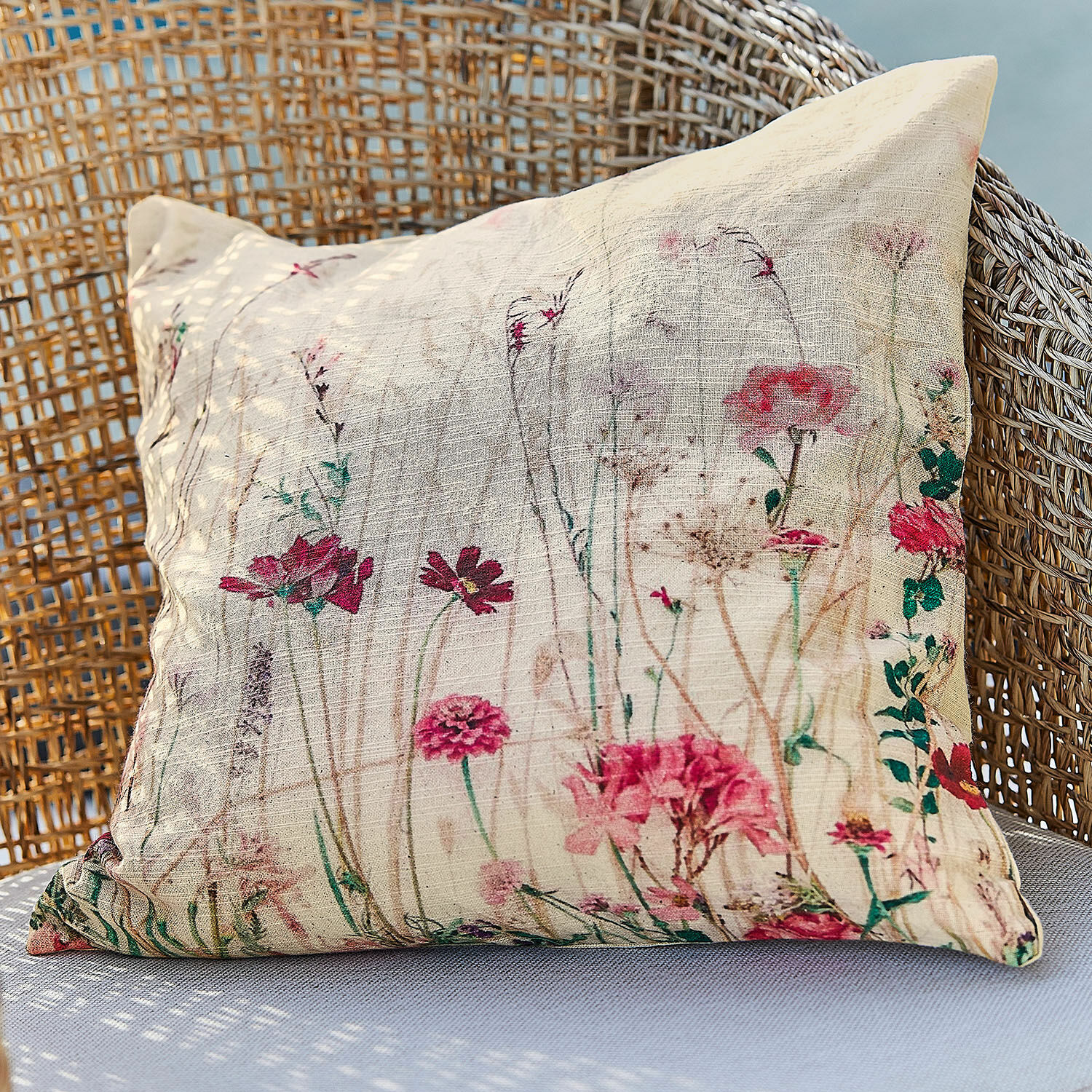 Funda de cojín Briovene Cojín beige de tela natural con estampado floral sobre sillón de mimbre, decoración para el hogar