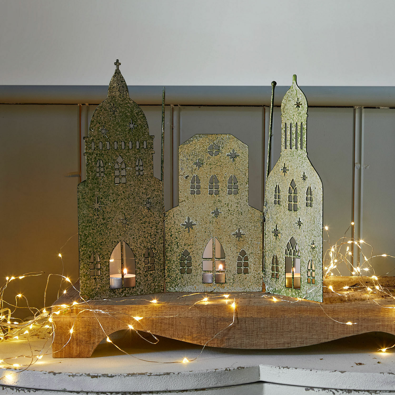 Casitas decorativas Roskilde Decoración metálica con tres edificios y velas, color verde dorado, adorno navideño LED para ambiente cálido