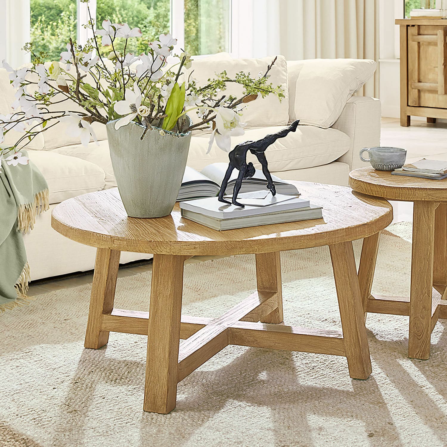 Mesa de centro Gorivel Mesa de centro redonda de madera de roble natural con decoración y libros en sala luminosa
