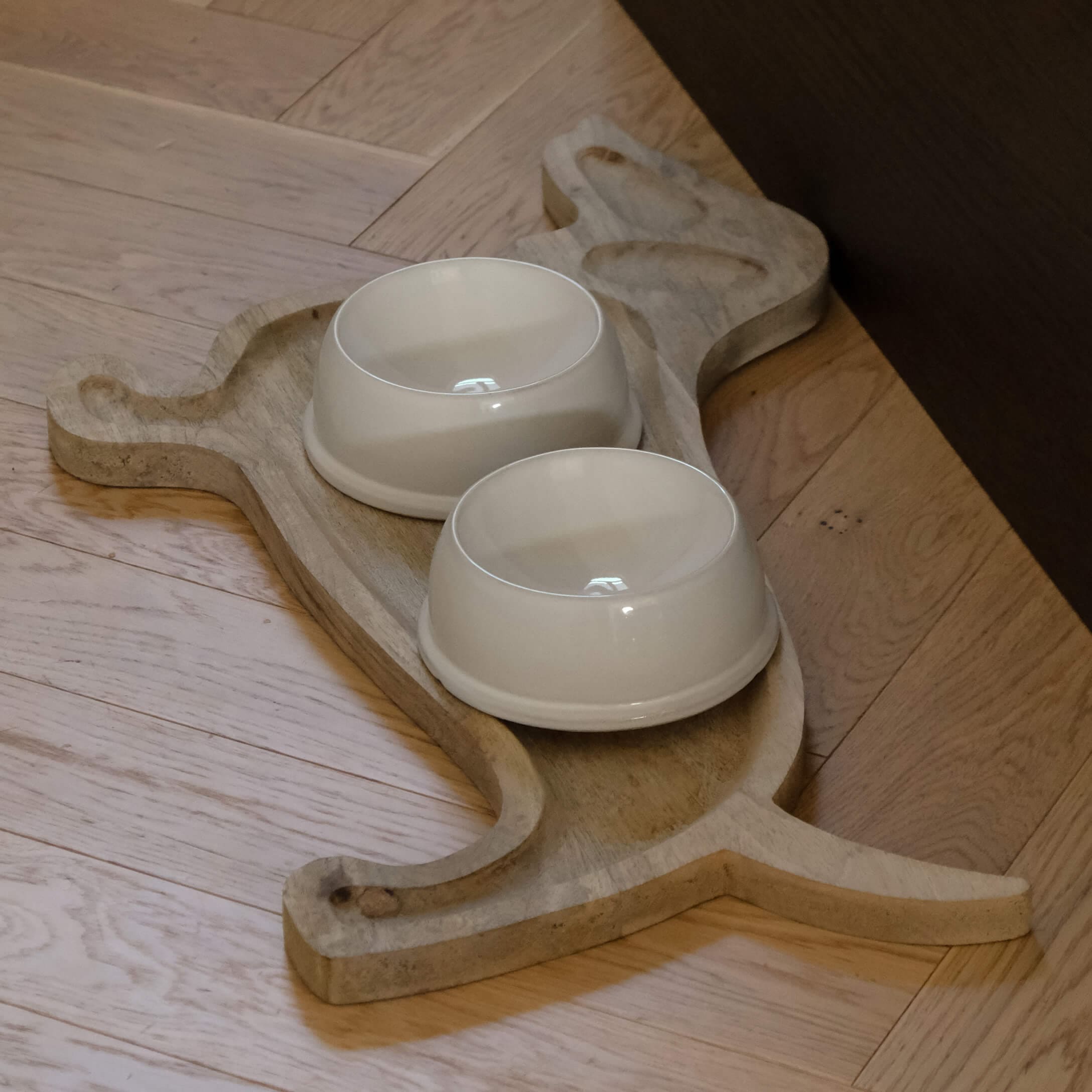 Base de madera con forma de gato y dos cuencos de cerámica crema para mascotas