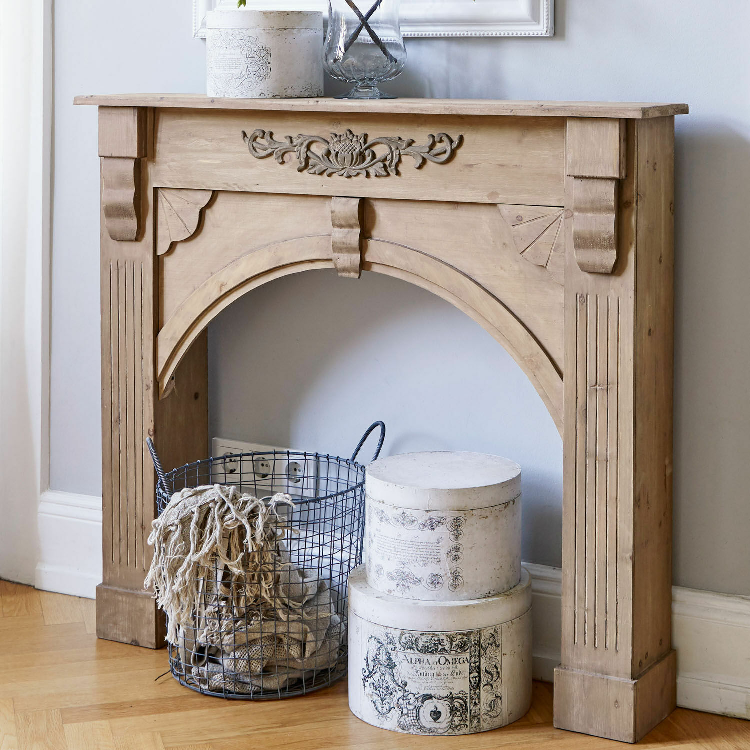 Consola de chimenea Maxwell Marco de chimenea de madera natural tallada con cesta metálica y cajas decorativas blancas