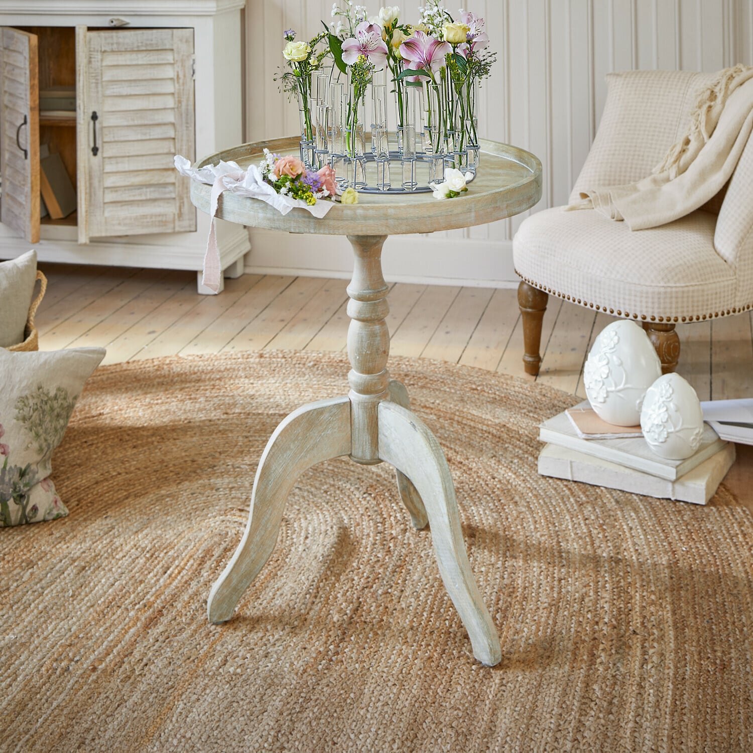 Mesa auxiliar Brookdale Mesa redonda de madera clara estilo vintage con decoración floral sobre la superficie en sala acogedora