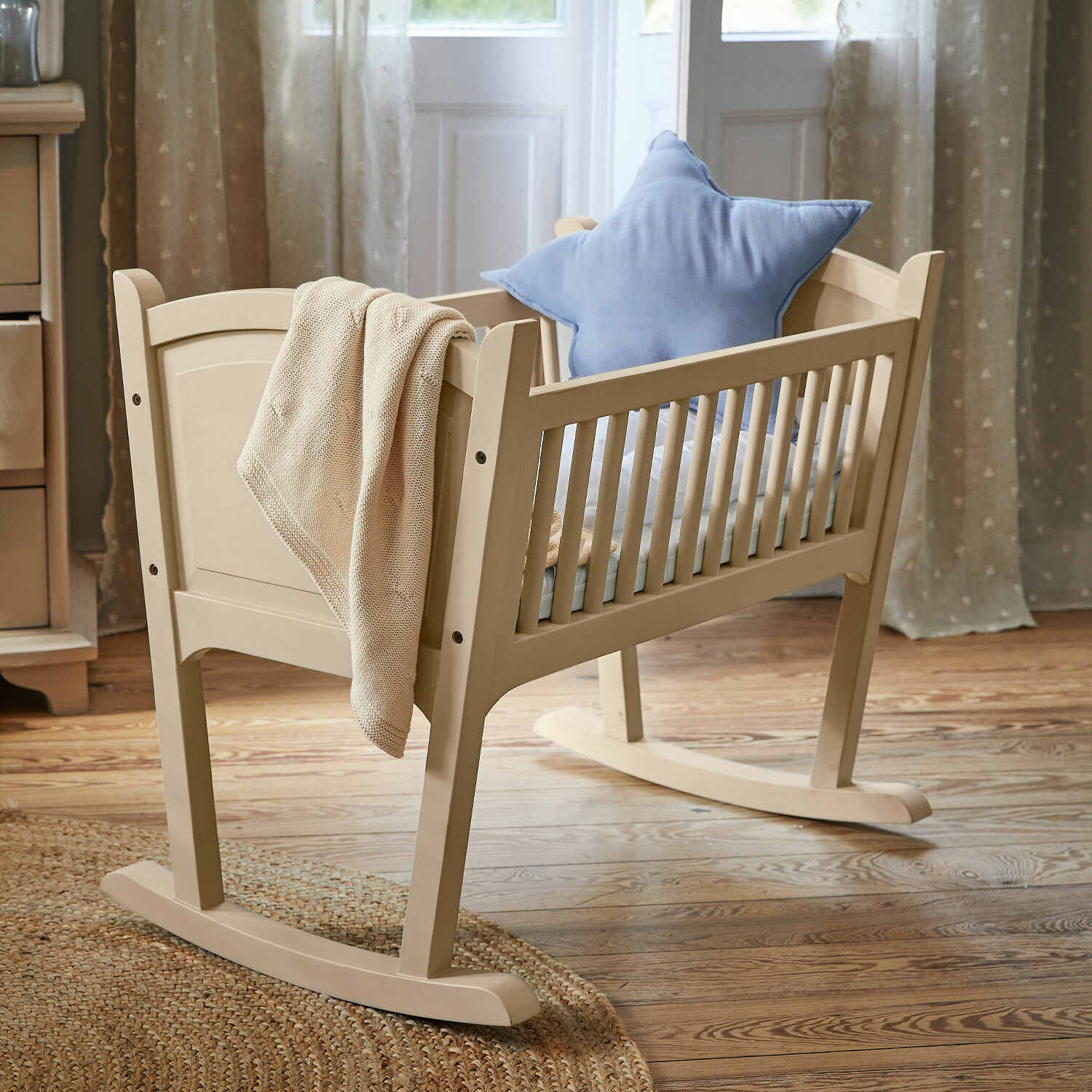 Cuna Aiguillon Mecedora infantil de madera beige con cojín azul en forma de estrella y manta tejida