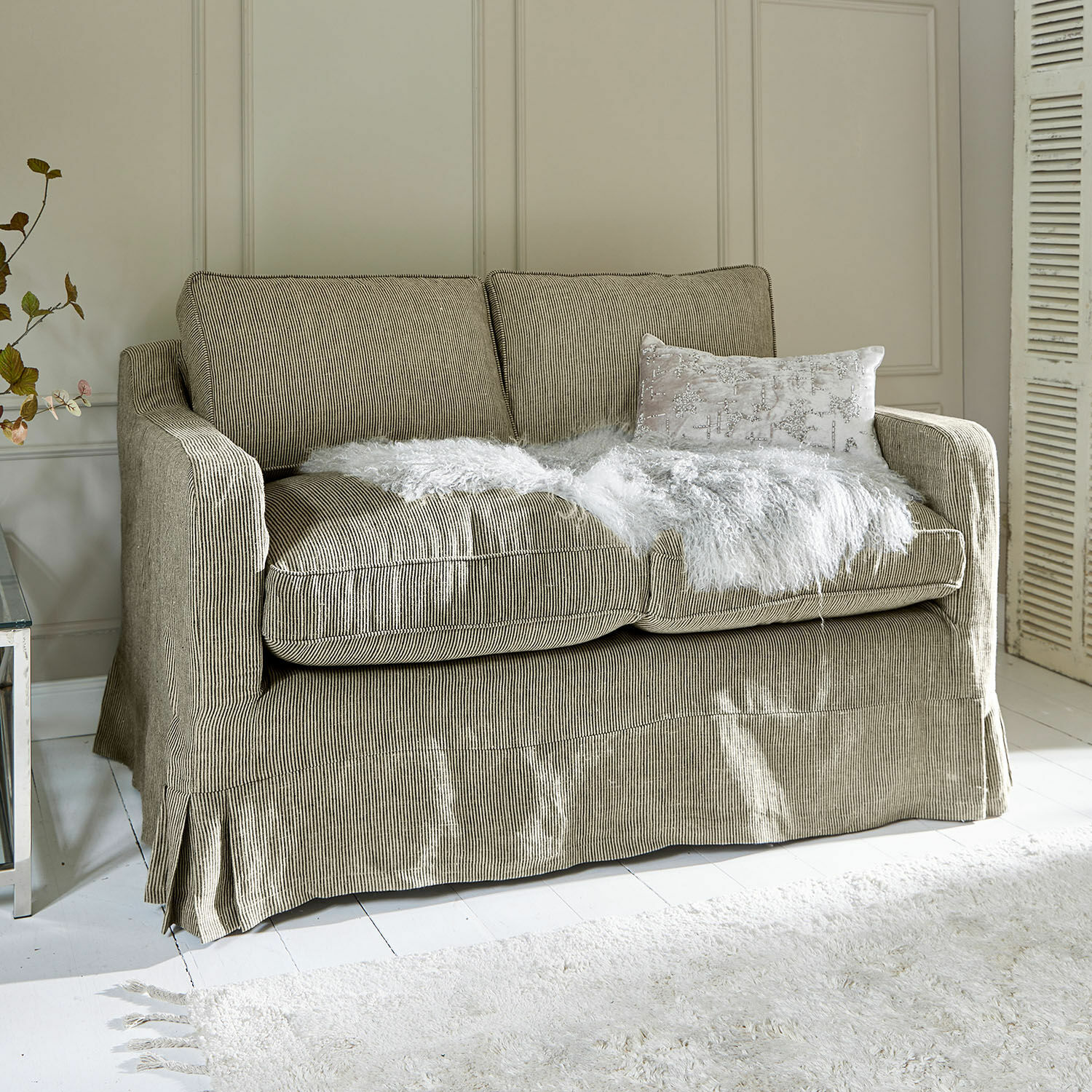 Sofá Briarcliff Sofá de dos plazas en tela beige a rayas con manta blanca de piel sintética y cojín decorativo