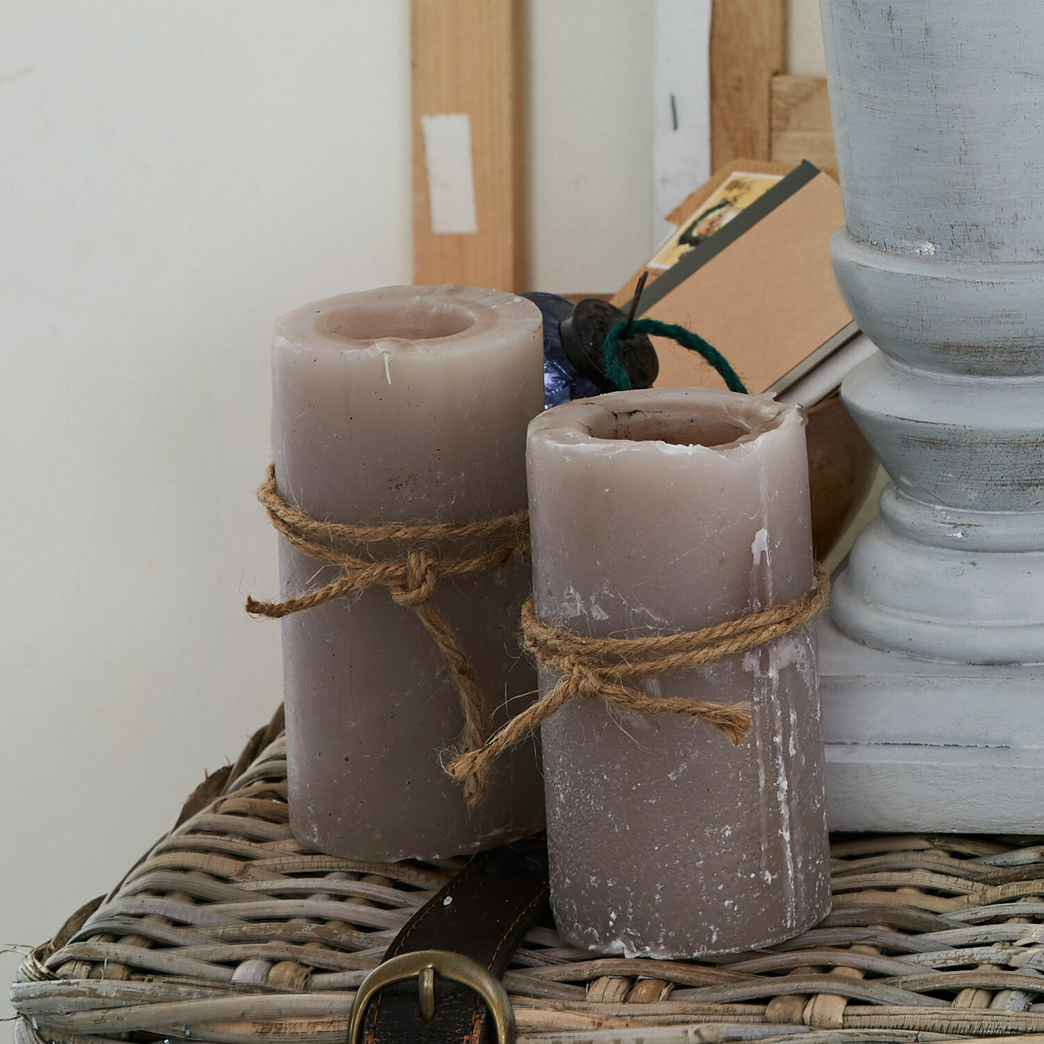 Set de 4 velas Braga Dos velas grises de cera con cuerda de yute sobre cesta de mimbre, decoración interior