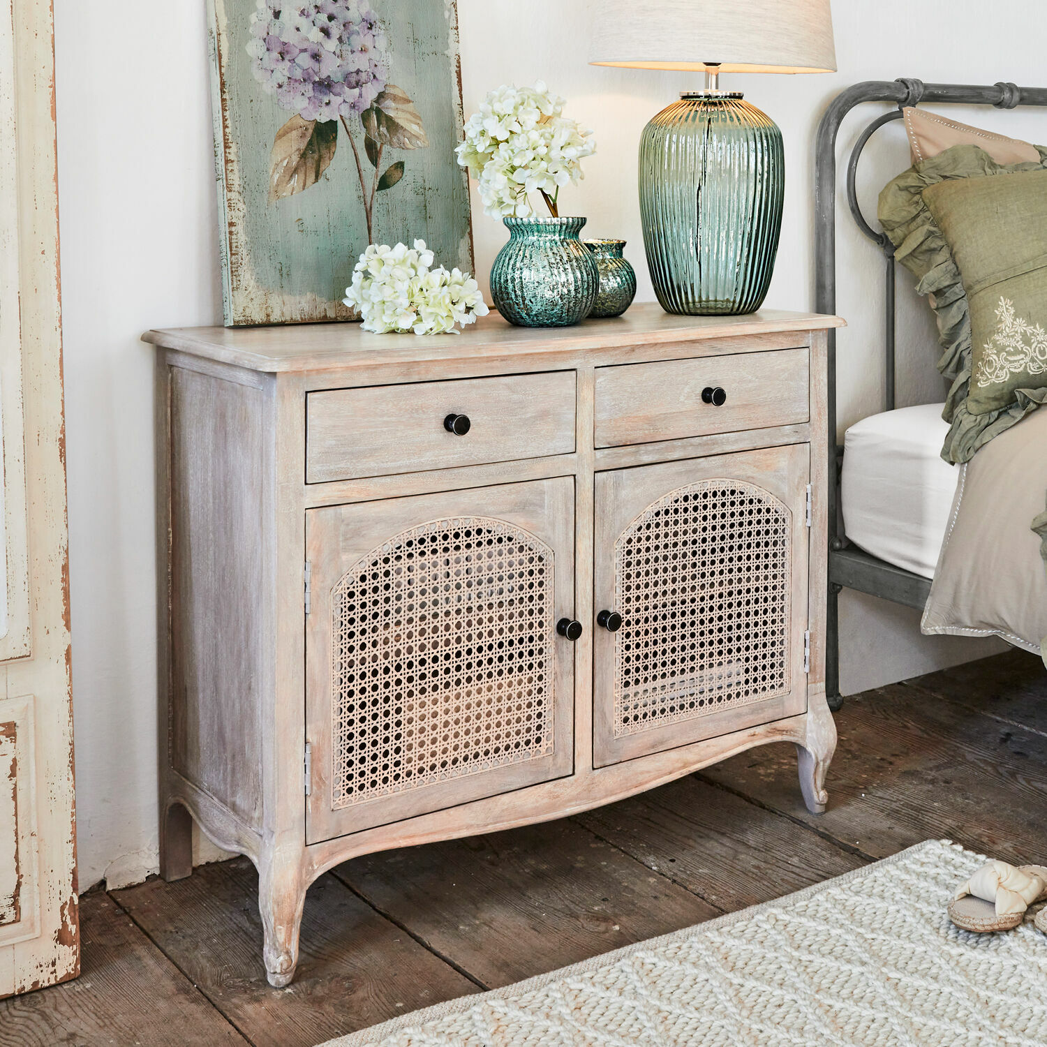 Cómoda Truso Cómoda de madera clara con puertas de rejilla, decoraciones y lámpara encima