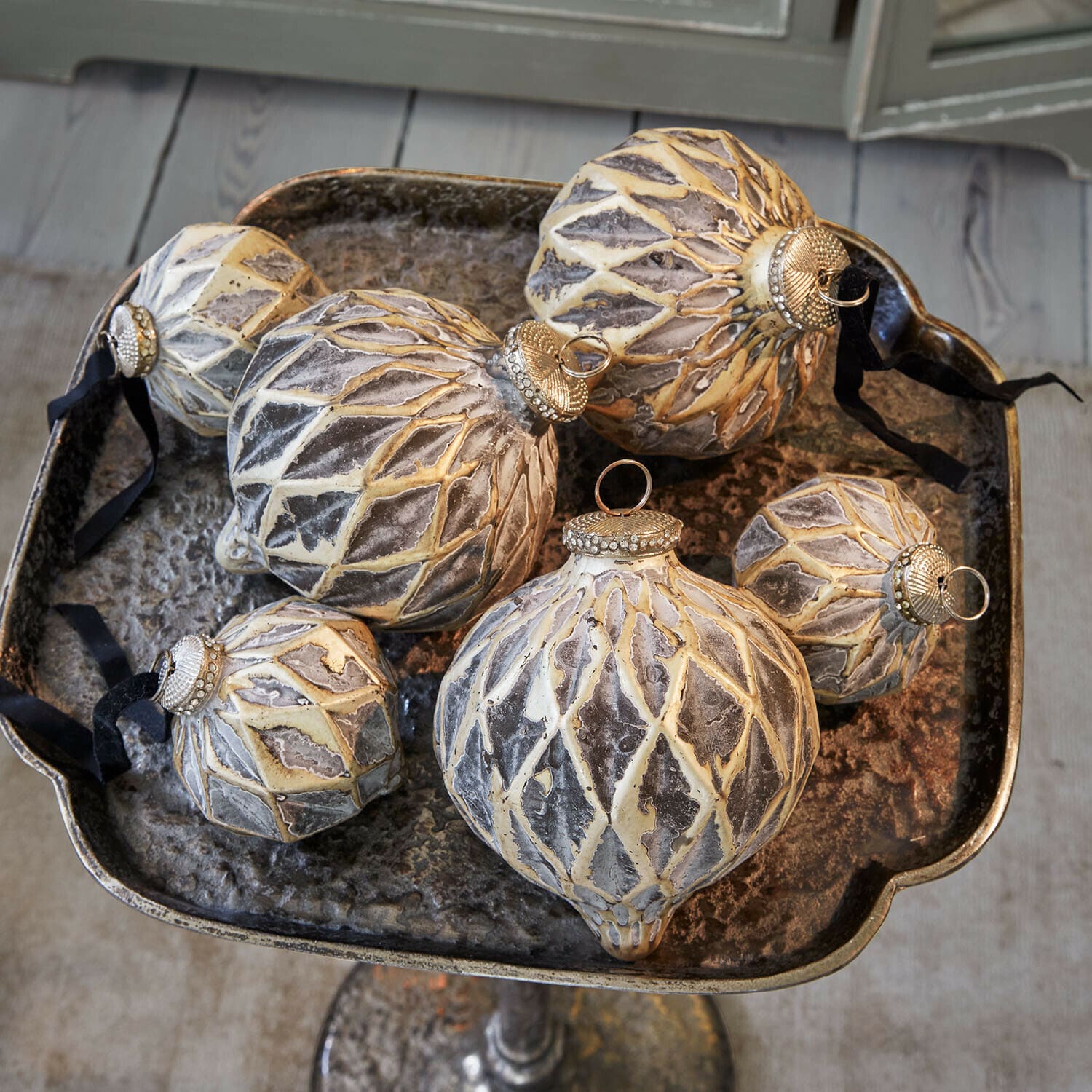 Set de 6 bolas de Navidad Lunagh Conjunto de seis bolas navideñas decorativas en gris-beige con ganchos metálicos sobre bandeja metálica