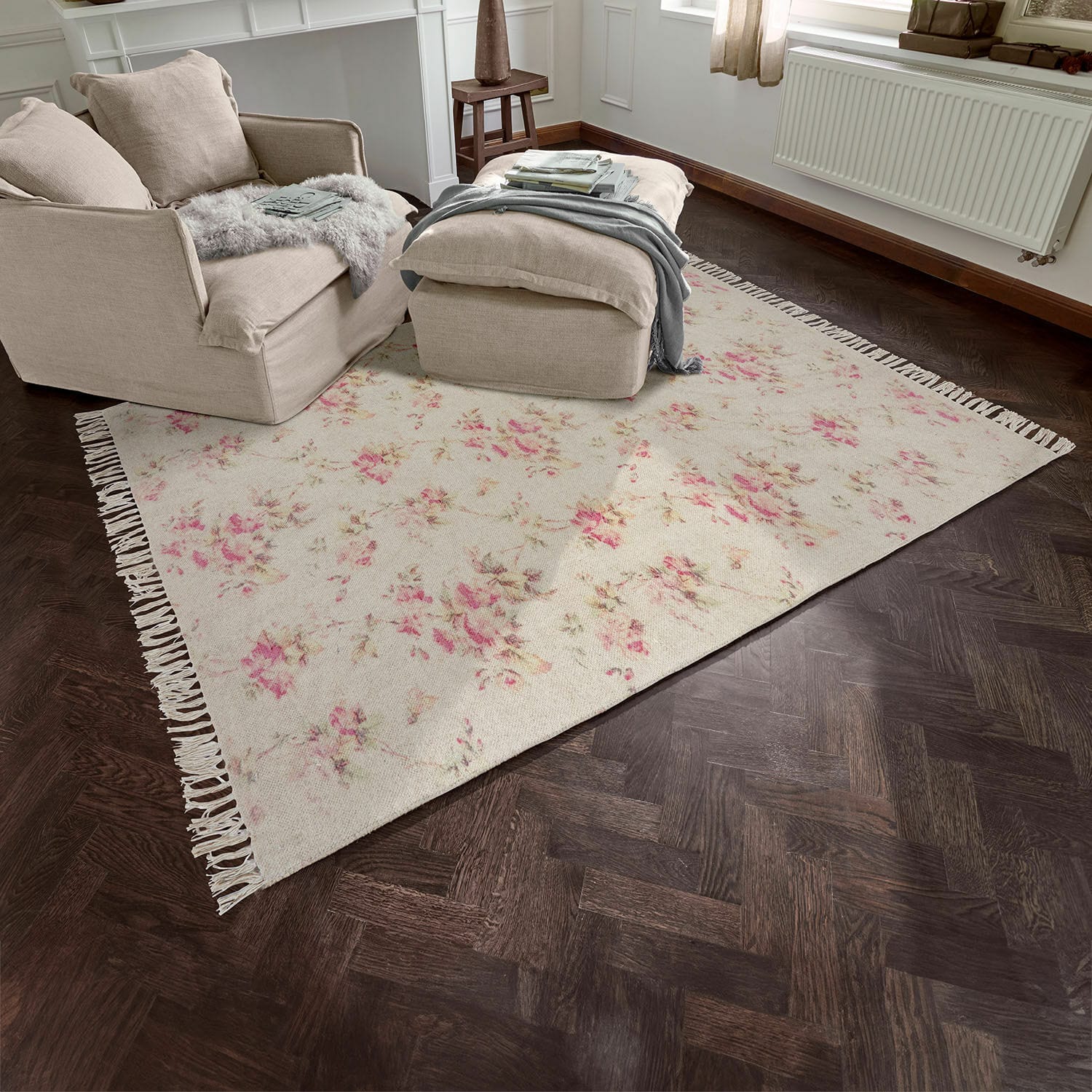 Alfombra Ingvi Alfombra beige con diseño floral y flecos sobre suelo de madera oscura en sala de estar