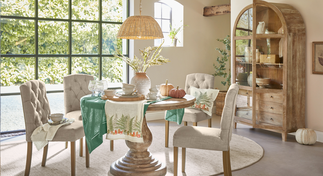 Comedor con mesa redonda de madera y sillas tapizadas beige en estilo natural