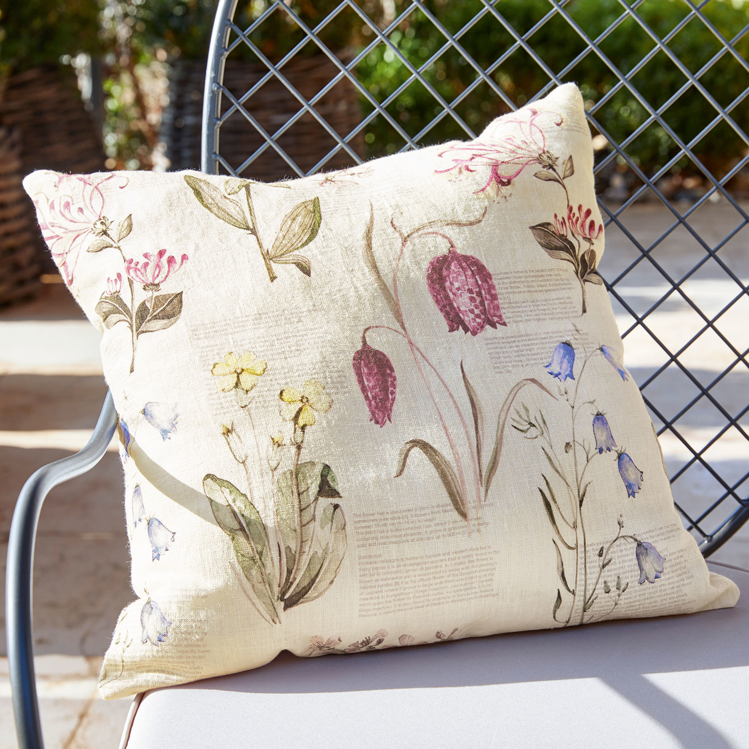 Funda de cojín Fournier Cojín de lino beige con estampado floral vintage sobre silla de jardín