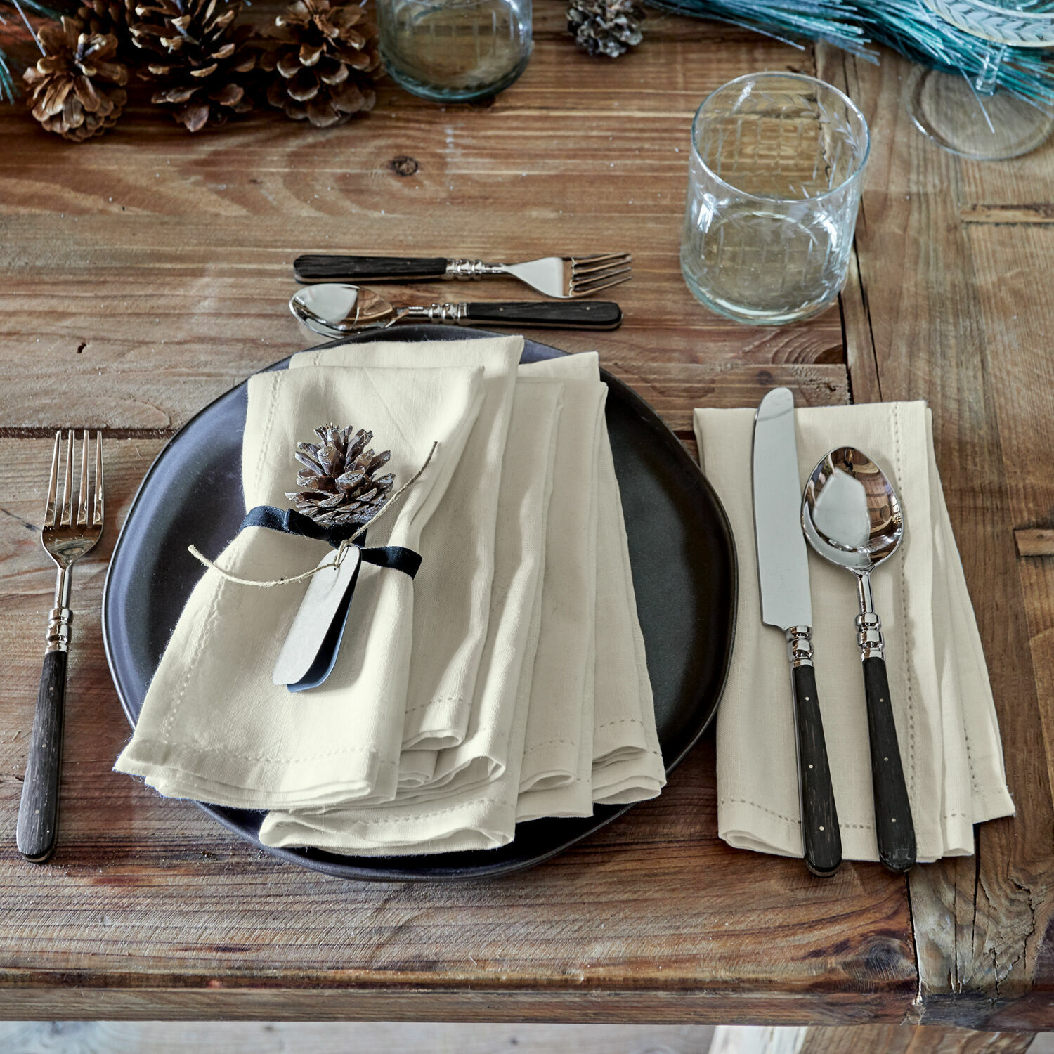 Set de 6 servilletas Fibi Mesa rústica de madera con plato negro, servilletas de lino crema y cubiertos con mango negro
