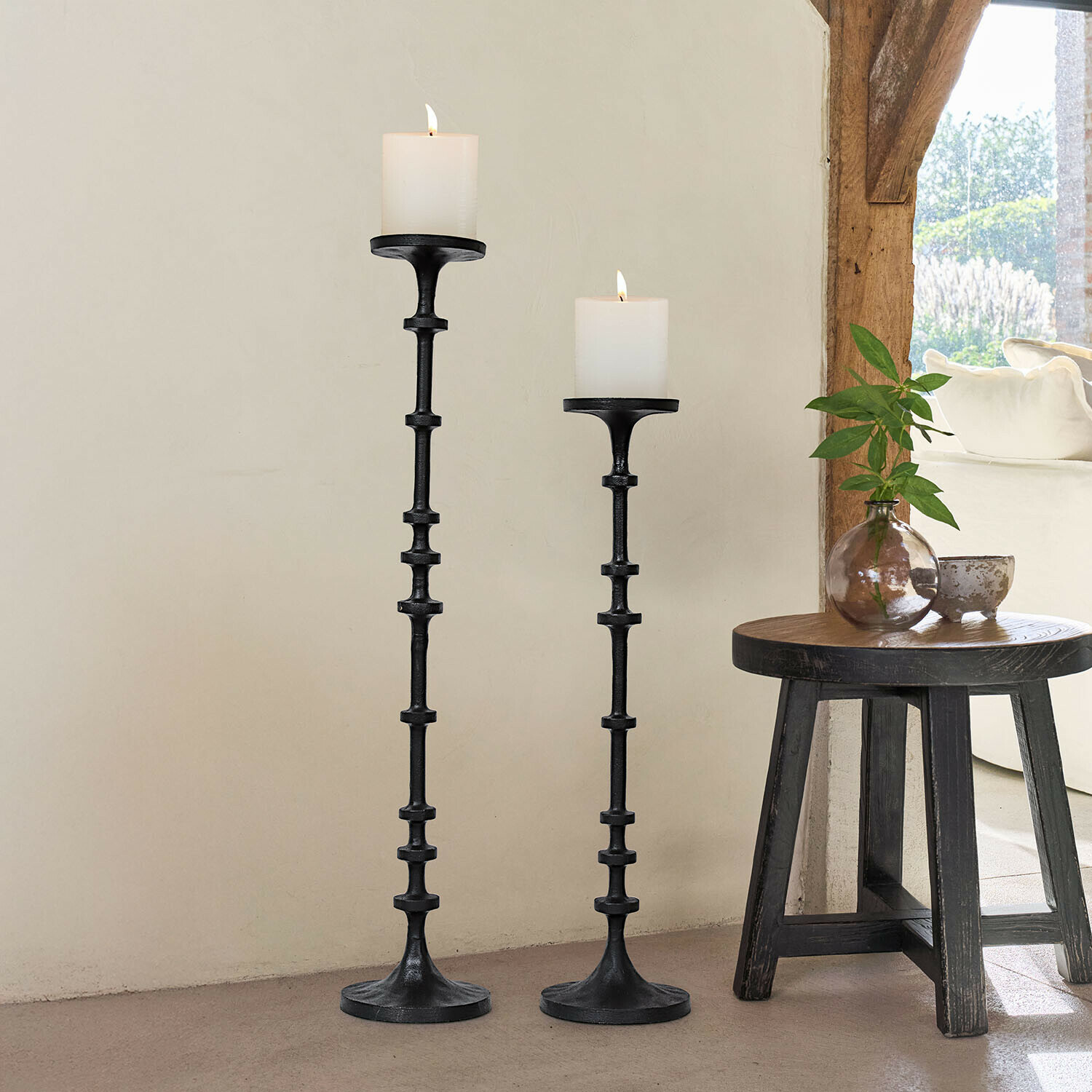 Set de 2 candeleros Reville Conjunto de dos candelabros de metal negro con velas blancas, decoración interior con luz natural