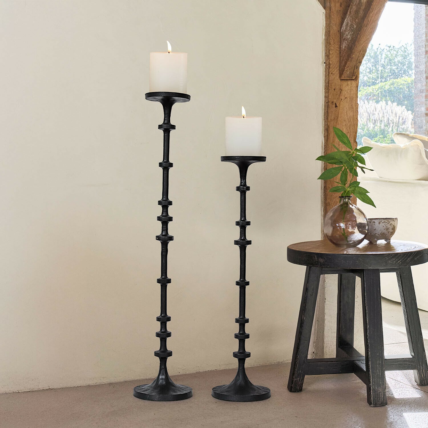 Set de 2 candeleros Reville Conjunto de dos candelabros de metal negro con velas blancas, decoración interior con luz natural