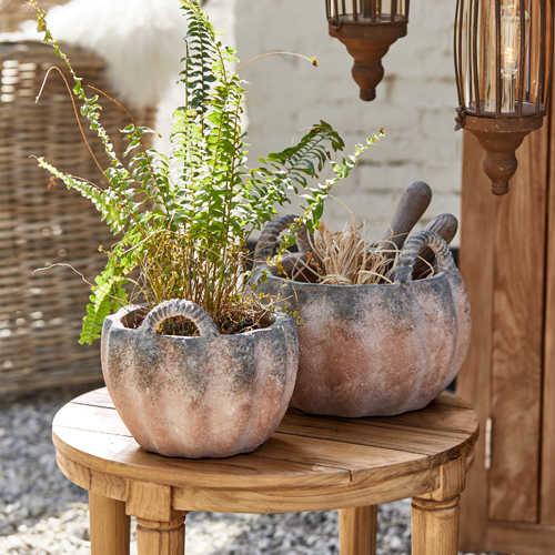 Dos macetas de cerámica rústicas con forma de calabaza sobre mesa de madera, decoración de jardín