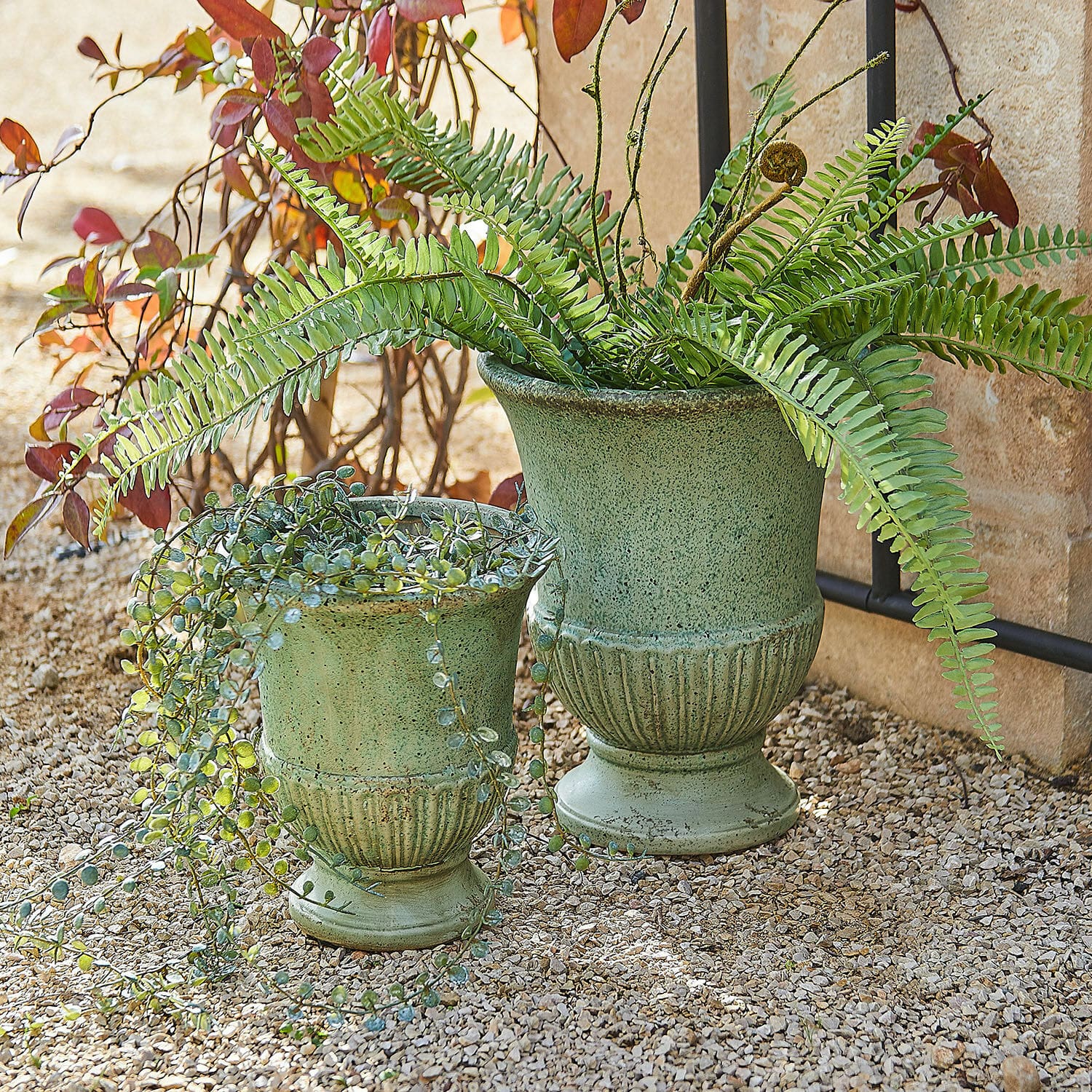 Set de 2 ánforas Jolivaux Conjunto de dos macetas de cerámica verde con plantas sobre suelo de grava exterior